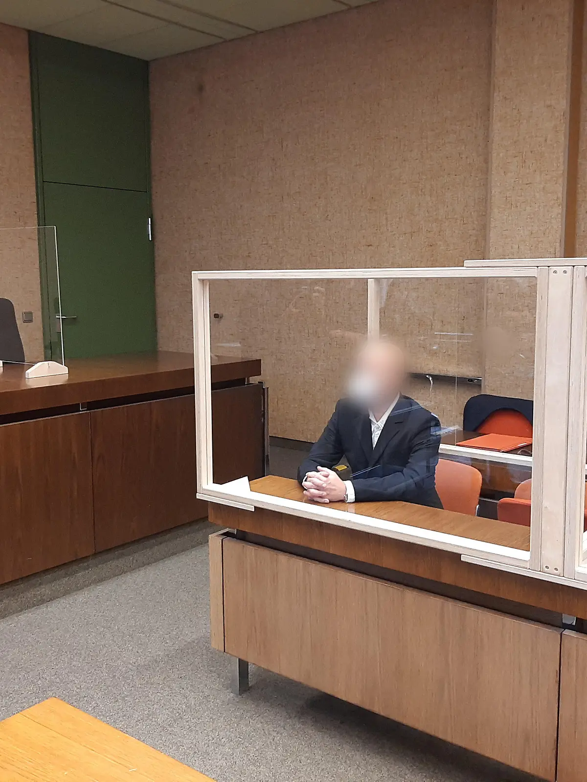 07.07.2022, Bayern, München: Der Angeklagte sitzt auf der Anklagebank und wird von einem Fotografen fotografiert. Dem Mann wirft die Staatsanwaltschaft vor, die beiden im rheinland-pfälzischen Kusel getöteten Polizisten verunglimpft haben. Foto: Britta Schultejans/dpa +++ dpa-Bildfunk +++