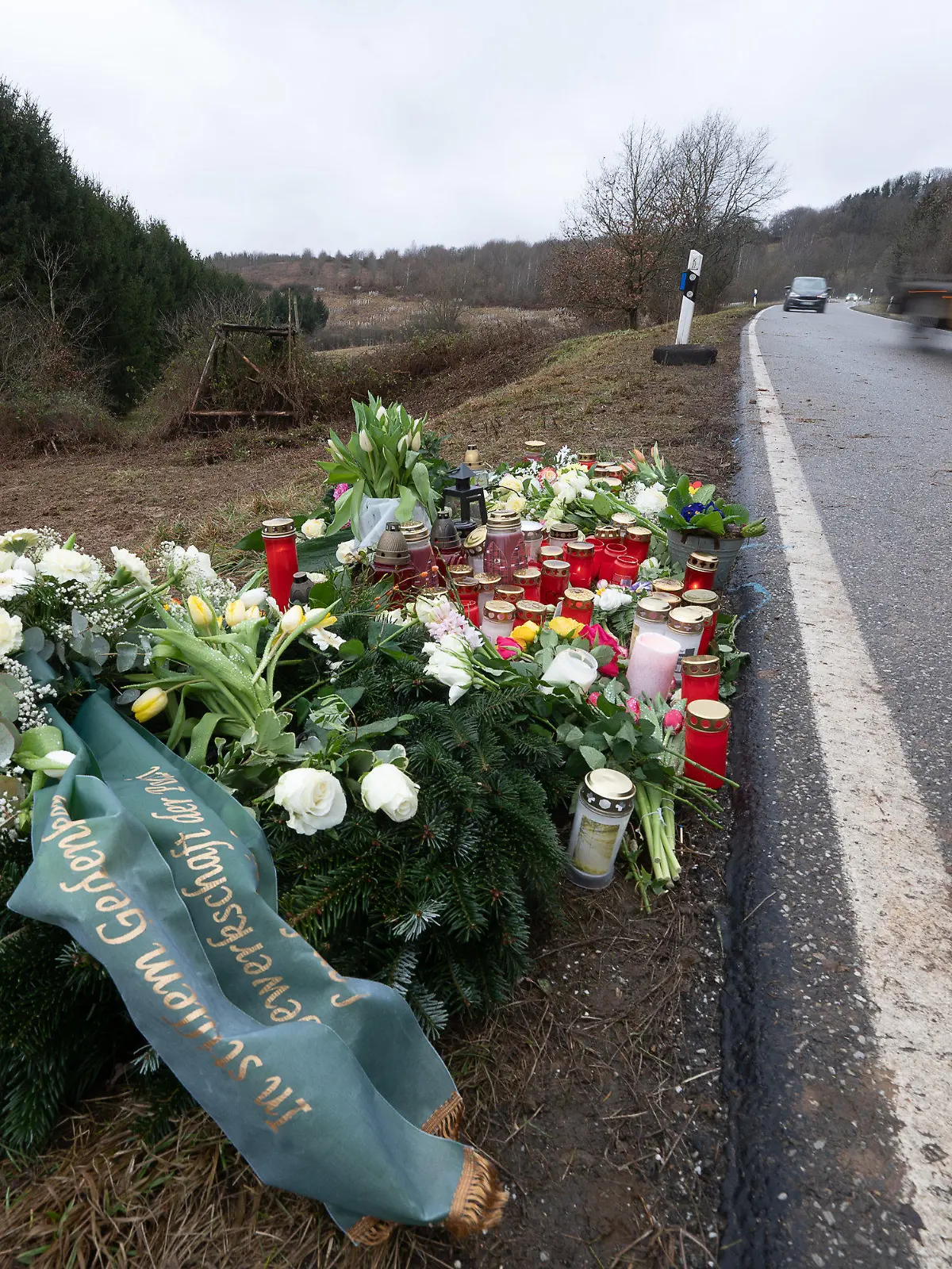 ARCHIV - 04.02.2022, Rheinland-Pfalz, Ulmet: Blumen und Kerzen stehen an dem Tatort, an dem Ende Januar 2022 bei Kusel zwei Polizeibeamte bei einer Verkehrskontrolle erschossen wurden. (zu dpa «Die Stille nach dem Hilferuf - Erste Zeugen in Polizistenmord-Prozess») Foto: Sebastian Gollnow/dpa +++ dpa-Bildfunk +++