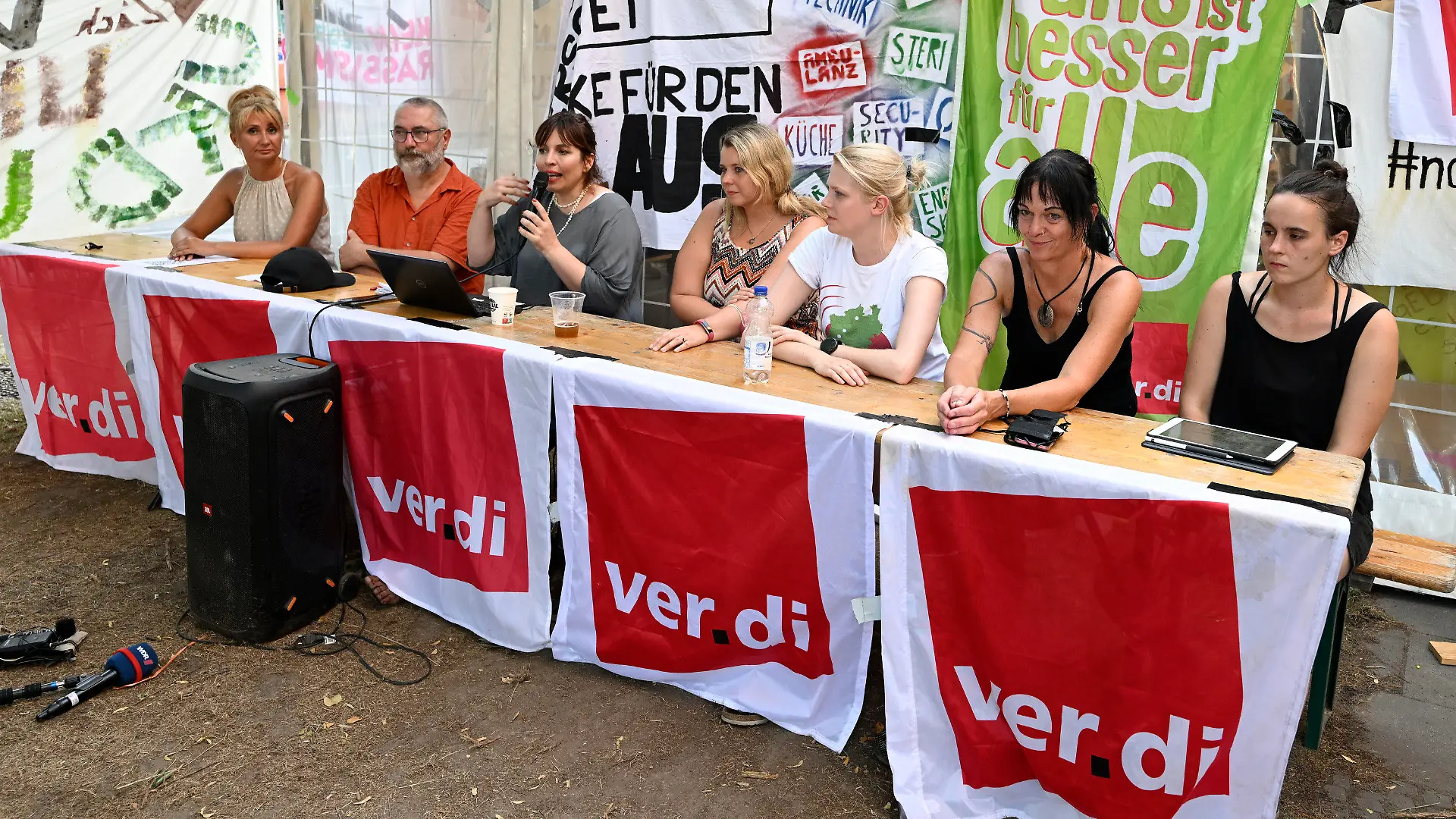 19.07.2022, Nordrhein-Westfalen, Köln: Katharina Wesenick (3.v.l.), Verdi-Landesfachbereichsleiterin Gesundheit in Nordrhein-Westfalen, erläutert die Tarifeinigung zusammen mit anderen Gewerkschaftsvertretern. Mehr als elf Wochen dauerten die Streiks an den sechs nordrhein-westfälischen Unikliniken. Jetzt haben sich die Parteien geeinigt. Zentrale Punkte der Einigung seien ein besserer Personalschlüssel insbesondere in patientennahen Berufsgruppen, eine schichtgenaue Belastungsmessung durch freie Tage oder finanziellen Ausgleich und Entlastungstage bei Unterschreiten der neuen Personalschlüssel. Foto: Roberto Pfeil/dpa +++ dpa-Bildfunk +++