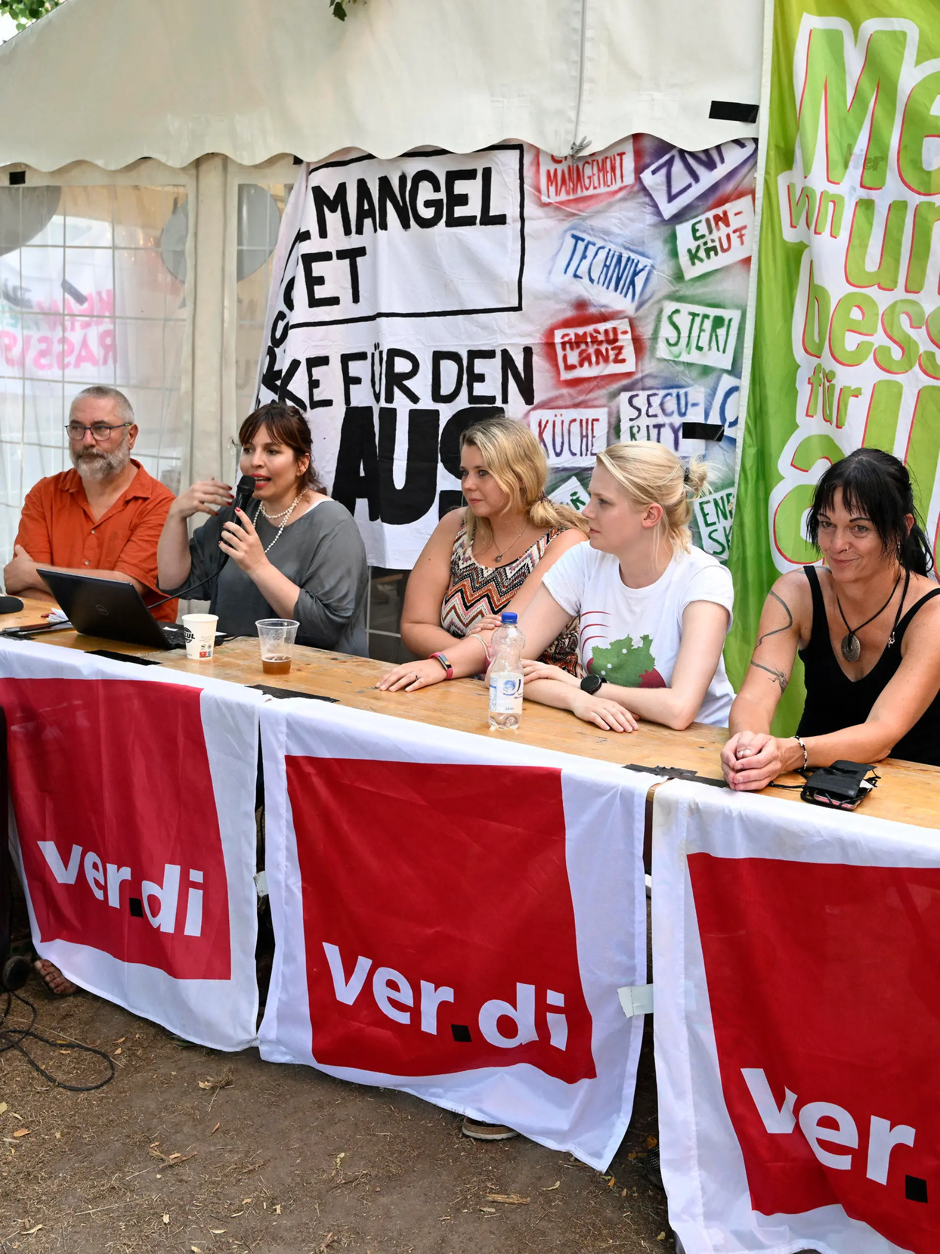 19.07.2022, Nordrhein-Westfalen, Köln: Katharina Wesenick (3.v.l.), Verdi-Landesfachbereichsleiterin Gesundheit in Nordrhein-Westfalen, erläutert die Tarifeinigung zusammen mit anderen Gewerkschaftsvertretern. Mehr als elf Wochen dauerten die Streiks an den sechs nordrhein-westfälischen Unikliniken. Jetzt haben sich die Parteien geeinigt. Zentrale Punkte der Einigung seien ein besserer Personalschlüssel insbesondere in patientennahen Berufsgruppen, eine schichtgenaue Belastungsmessung durch freie Tage oder finanziellen Ausgleich und Entlastungstage bei Unterschreiten der neuen Personalschlüssel. Foto: Roberto Pfeil/dpa +++ dpa-Bildfunk +++