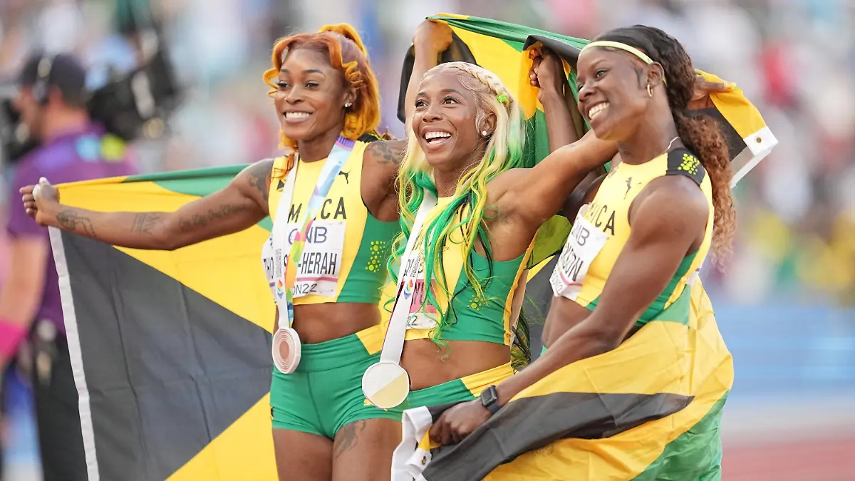 17.07.2022, USA, Eugene: Leichtathletik; Weltmeisterschaft, 100 m Shelly-Ann Fraser-Pryce (M) aus Jamaika ist Weltmeisterin daneben Elaine Thompson-Herah (l Bronze) und Shericka Jackson (Silber). Foto: Michael Kappeler/dpa +++ dpa-Bildfunk +++