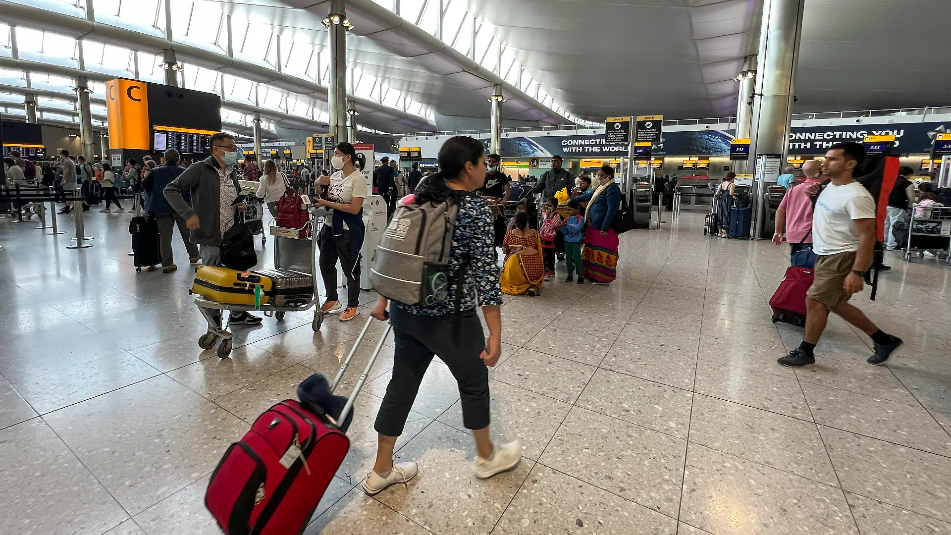 13.07.2022, Großbritannien, London: Reisende stehen am Flughafen Heathrow. Der Londoner Flughafen Heathrow hat ein Limit für die Zahl abreisender Passagiere für die Sommermonate eingeführt. Wie Geschäftsführer John Holland-Kaye am 12.07.22 in einem offenen Brief mitteilte, soll ab sofort bis zum 11. September eine Obergrenze von 100 000 Passagieren am Tag gelten. Foto: Alberto Pezzali/AP/dpa +++ dpa-Bildfunk +++