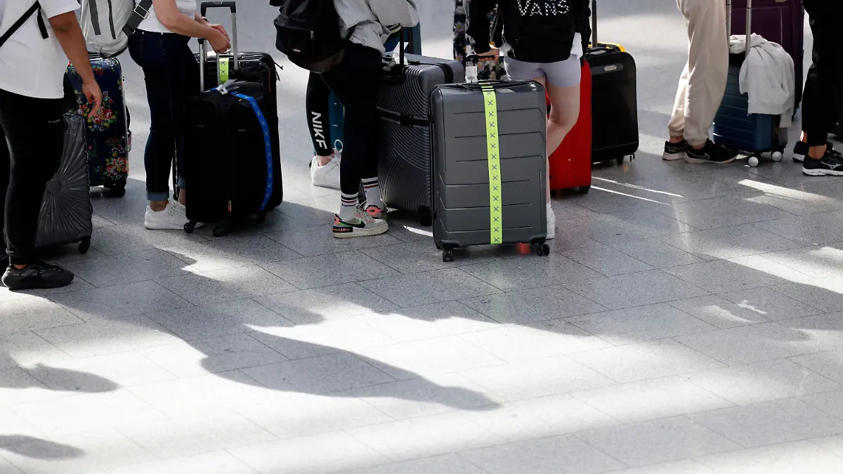 09.07.2022, Nordrhein-Westfalen, Düsseldorf: Passagiere stehen am dritten Ferienwochenende am Vormittag an Check-In-Schaltern der jeweiligen Airlines am Flughafen Düsseldorf an. Foto: Thomas Banneyer/dpa +++ dpa-Bildfunk +++