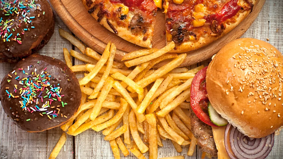 Closeup of home made burgers , french fries and donuts on wooden background