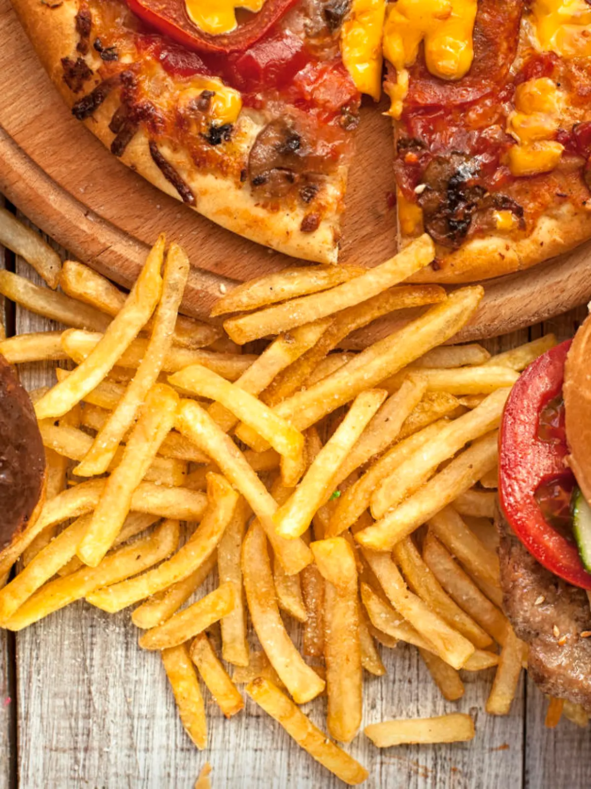 Closeup of home made burgers , french fries and donuts on wooden background