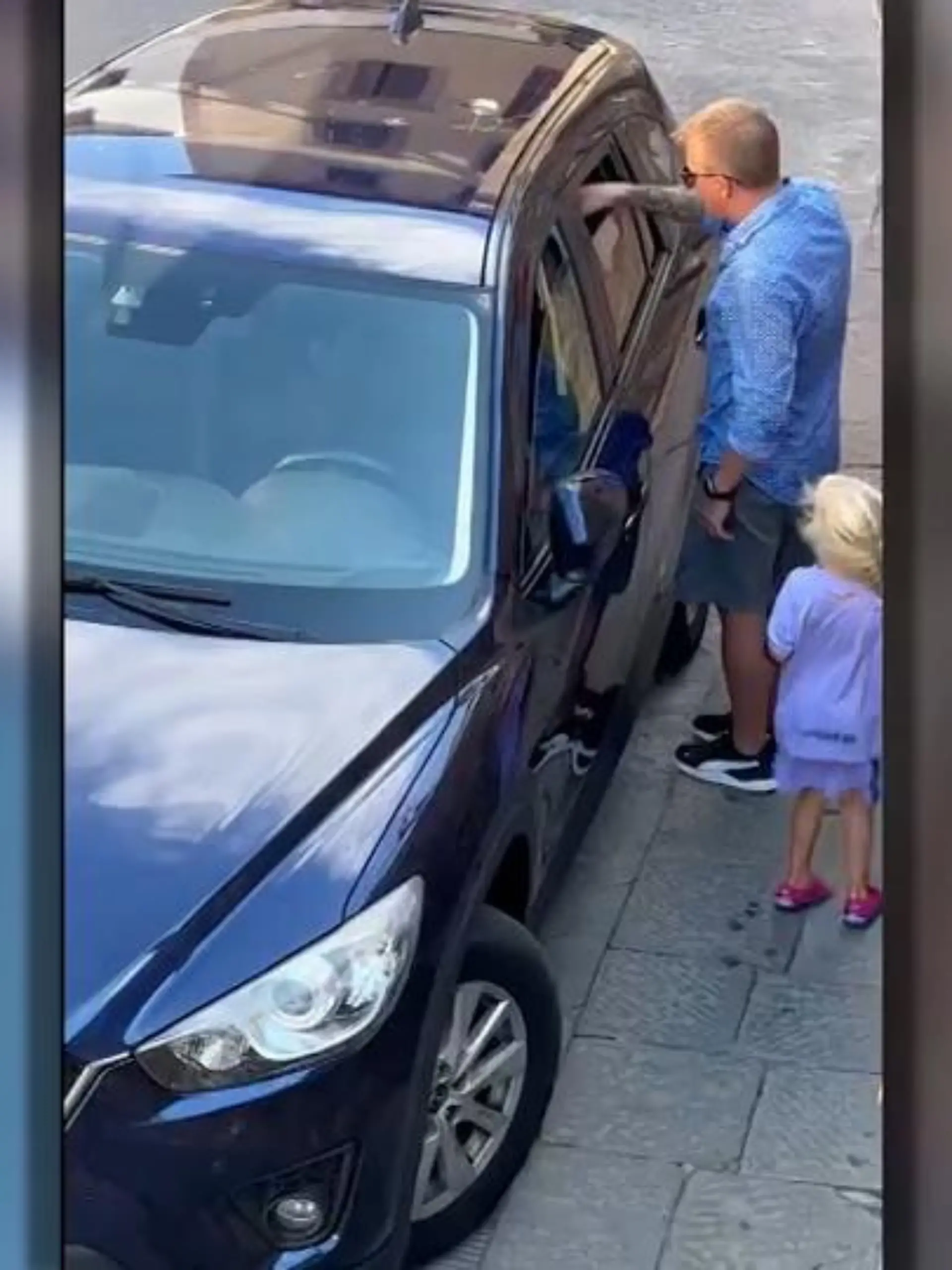 Kimi Räikkönen hilft in Italien einem Hund, der bei starker Hitze im Auto eingesperrt ist. Durch einen Spalt im Fenster gibt er dem Hund etwas Wasser.