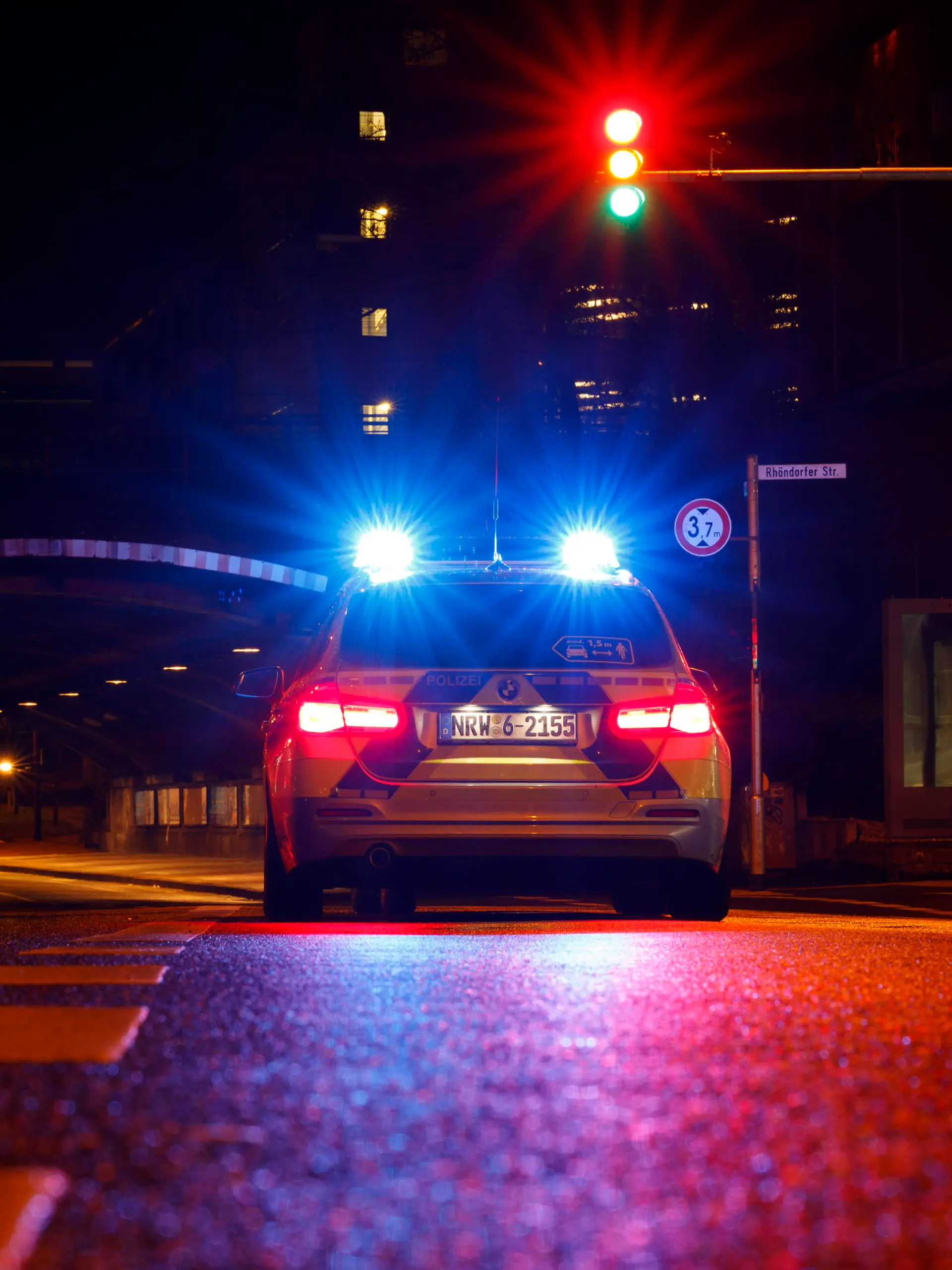 Ein Polizeiauto kontrolliert einen Wagen an einer Ampel. (Themenbild, Symbolbild) Köln, 20.01.2021