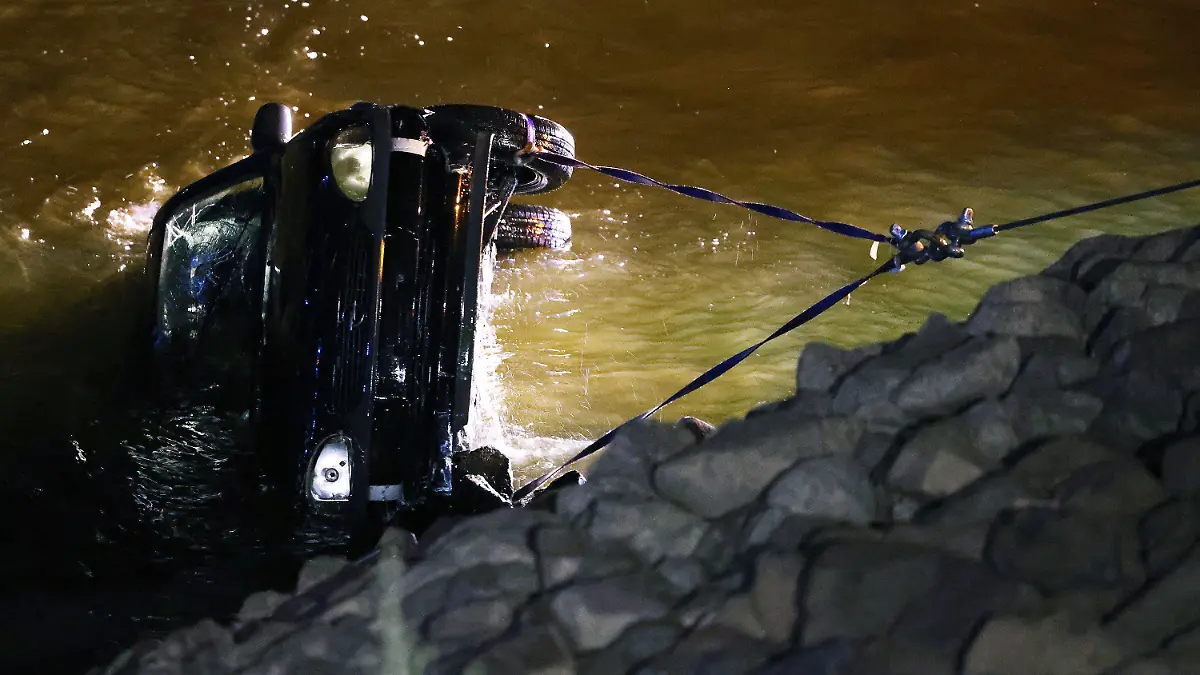 16.07.2022, Nordrhein-Westfalen, Düsseldorf: Polizisten und Feuerwehrleute ziehen einen Opel Corsa aus dem Rhein. Eine 23 Jahre alte Fahrerin hat bei einem missglückten Wendemanöver versehentlich das falsche Pedal getreten. Das Auto sei vom Parkplatz direkt in den Rhein gefahren und komplett versunken. Foto: David Young/dpa +++ dpa-Bildfunk +++