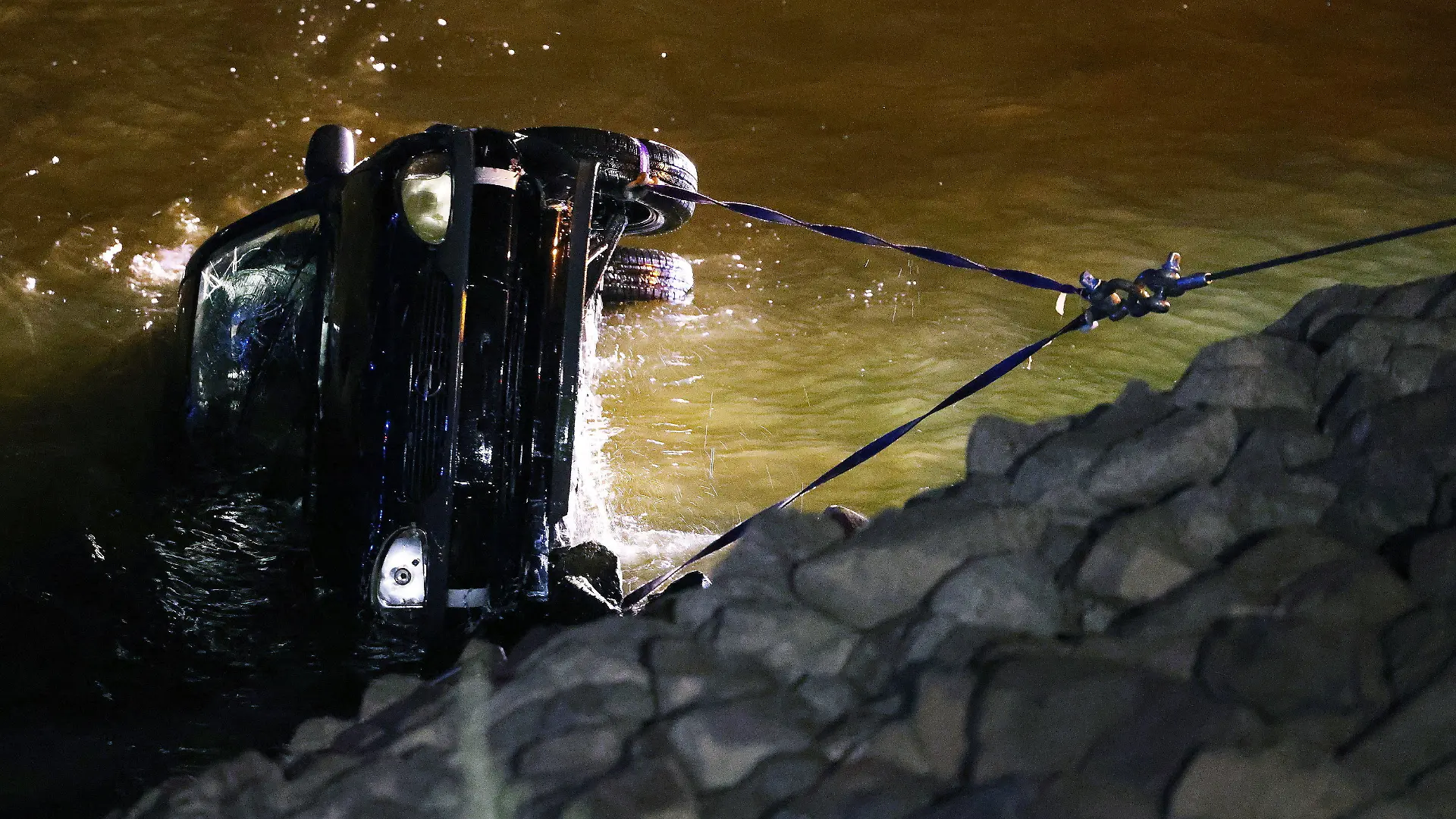 16.07.2022, Nordrhein-Westfalen, Düsseldorf: Polizisten und Feuerwehrleute ziehen einen Opel Corsa aus dem Rhein. Eine 23 Jahre alte Fahrerin hat bei einem missglückten Wendemanöver versehentlich das falsche Pedal getreten. Das Auto sei vom Parkplatz direkt in den Rhein gefahren und komplett versunken. Foto: David Young/dpa +++ dpa-Bildfunk +++