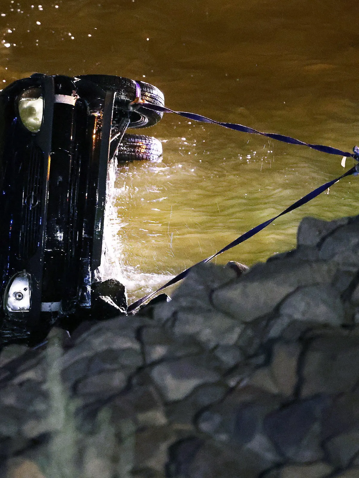 16.07.2022, Nordrhein-Westfalen, Düsseldorf: Polizisten und Feuerwehrleute ziehen einen Opel Corsa aus dem Rhein. Eine 23 Jahre alte Fahrerin hat bei einem missglückten Wendemanöver versehentlich das falsche Pedal getreten. Das Auto sei vom Parkplatz direkt in den Rhein gefahren und komplett versunken. Foto: David Young/dpa +++ dpa-Bildfunk +++