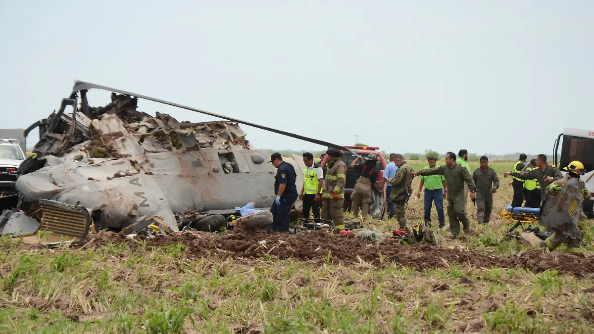 Emergency personnel work next to a navy Blackhawk helicopter crashed after supporting those who conducted the capture of drug lord Rafael Caro Quintero, near Los Mochis, Sinaloa state, Mexico, Friday, July 15, 2022. Mexico's navy said multiple people aboard died. (AP Photo/Guillermo Juarez)