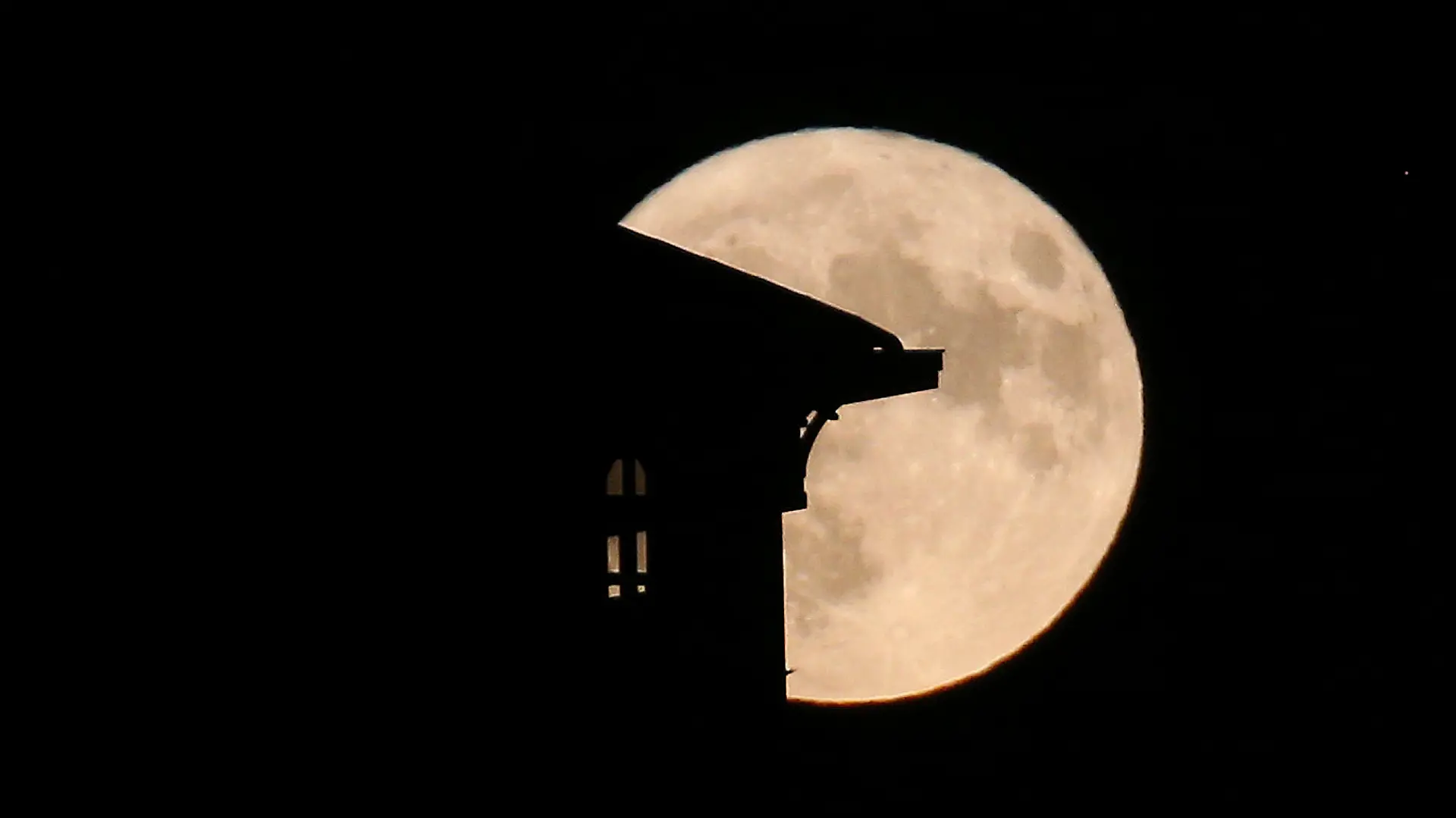 The supermoon rises behind a house in Saint Jean de Luz, southwestern France, Tuesday, Aug.1, 2023. The cosmos is offering up a double feature in August: a pair of supermoons culminating in a rare blue moon. (AP Photo/Bob Edme)