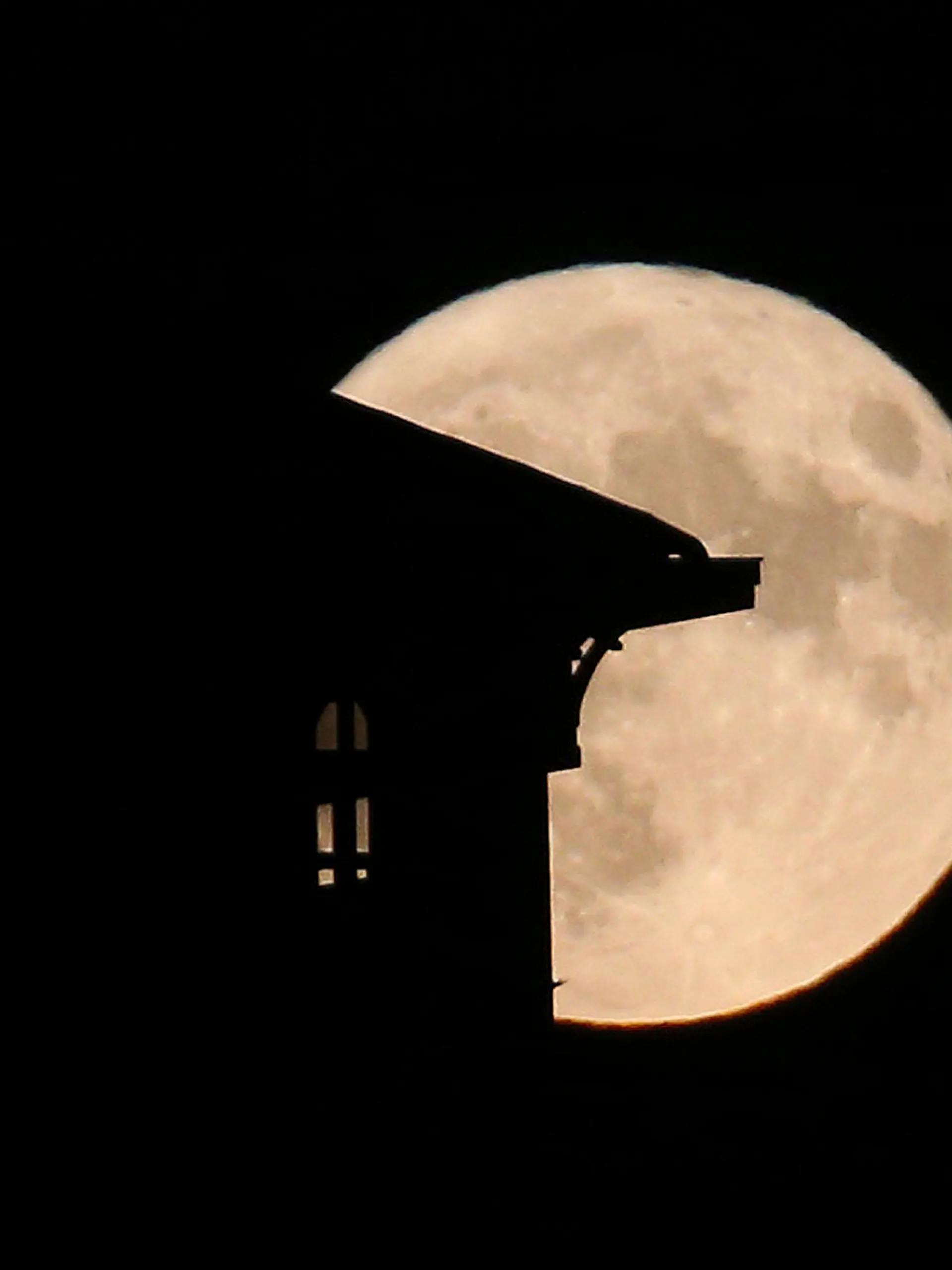 The supermoon rises behind a house in Saint Jean de Luz, southwestern France, Tuesday, Aug.1, 2023. The cosmos is offering up a double feature in August: a pair of supermoons culminating in a rare blue moon.  (AP Photo/Bob Edme)