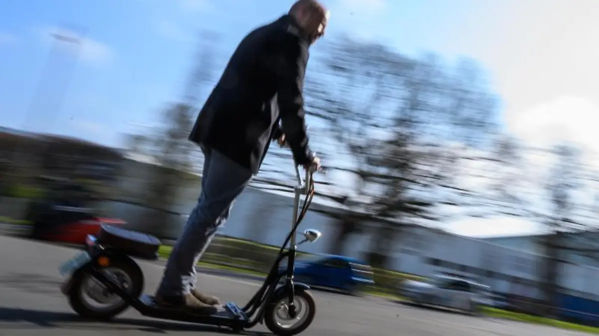 Ein Mann fährt auf einem Elektrotretroller