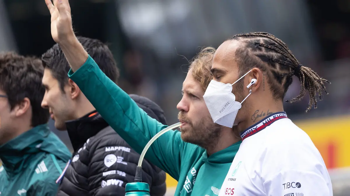 10.07.2022, Österreich, Spielberg: Motorsport: Formel-1-Weltmeisterschaft, Großer Preis von Österreich am Red Bull Ring, Vor dem Rennen, Drivers Parade: Sebastian Vettel (2.v.r) aus Deutschland vom Team Aston Martin trinkt und winkt neben Lewis Hamilton (r) aus Großbritannien von Team Mercedes während der Drivers Parade. Foto: Expa/Johann Groder/APA/dpa +++ dpa-Bildfunk +++