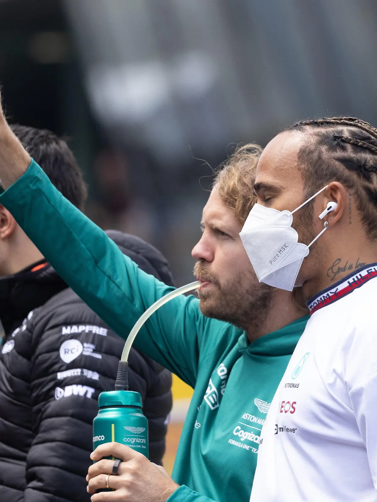 10.07.2022, Österreich, Spielberg: Motorsport: Formel-1-Weltmeisterschaft, Großer Preis von Österreich am Red Bull Ring, Vor dem Rennen, Drivers Parade: Sebastian Vettel (2.v.r) aus Deutschland vom Team Aston Martin trinkt und winkt neben Lewis Hamilton (r) aus Großbritannien von Team Mercedes während der Drivers Parade. Foto: Expa/Johann Groder/APA/dpa +++ dpa-Bildfunk +++