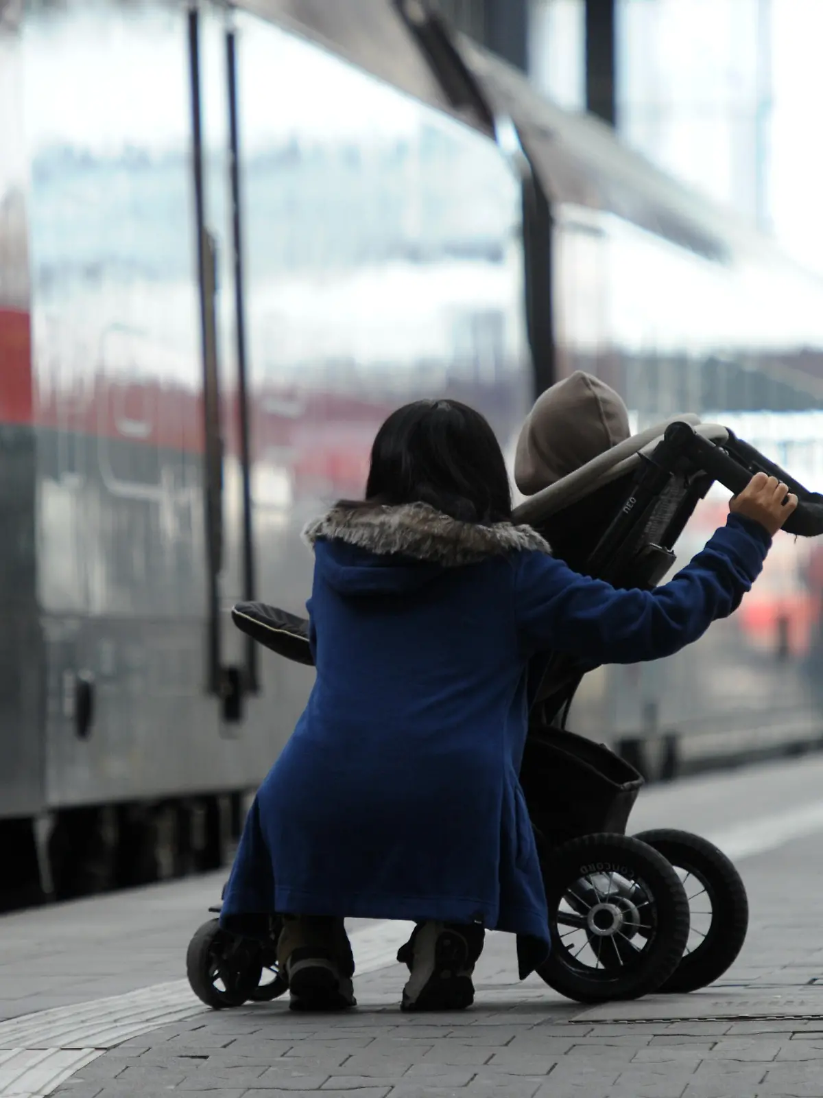Eine Frau und ein Kind im Kinderwagen warten am 18.10.2014 in München (Bayern) am Hauptbahnhof an einem Bahnsteig. Die Lokführer-Gewerkschaft (GDL) hat am Samstagmorgen einen Streik im Personenverkehr der Bahn begonnen. Foto: Tobias Hase/dpa | Verwendung weltweit