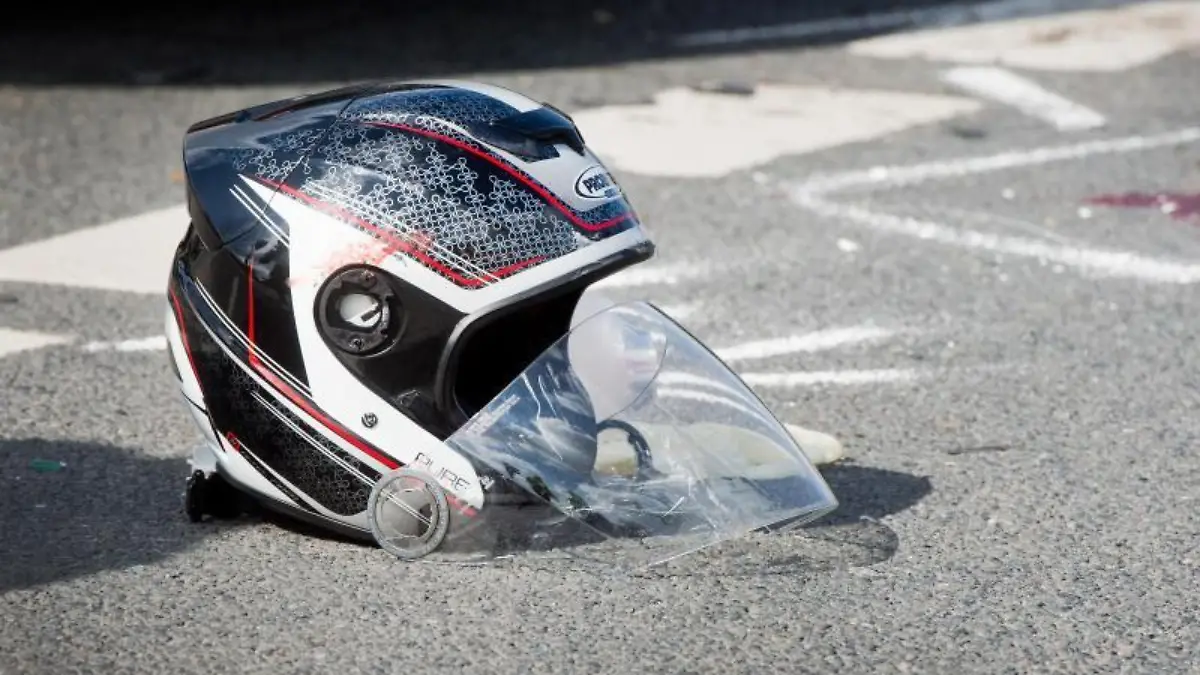 Ein beschädigter Motorradhelm liegt nach dem Unfall auf dem Boden