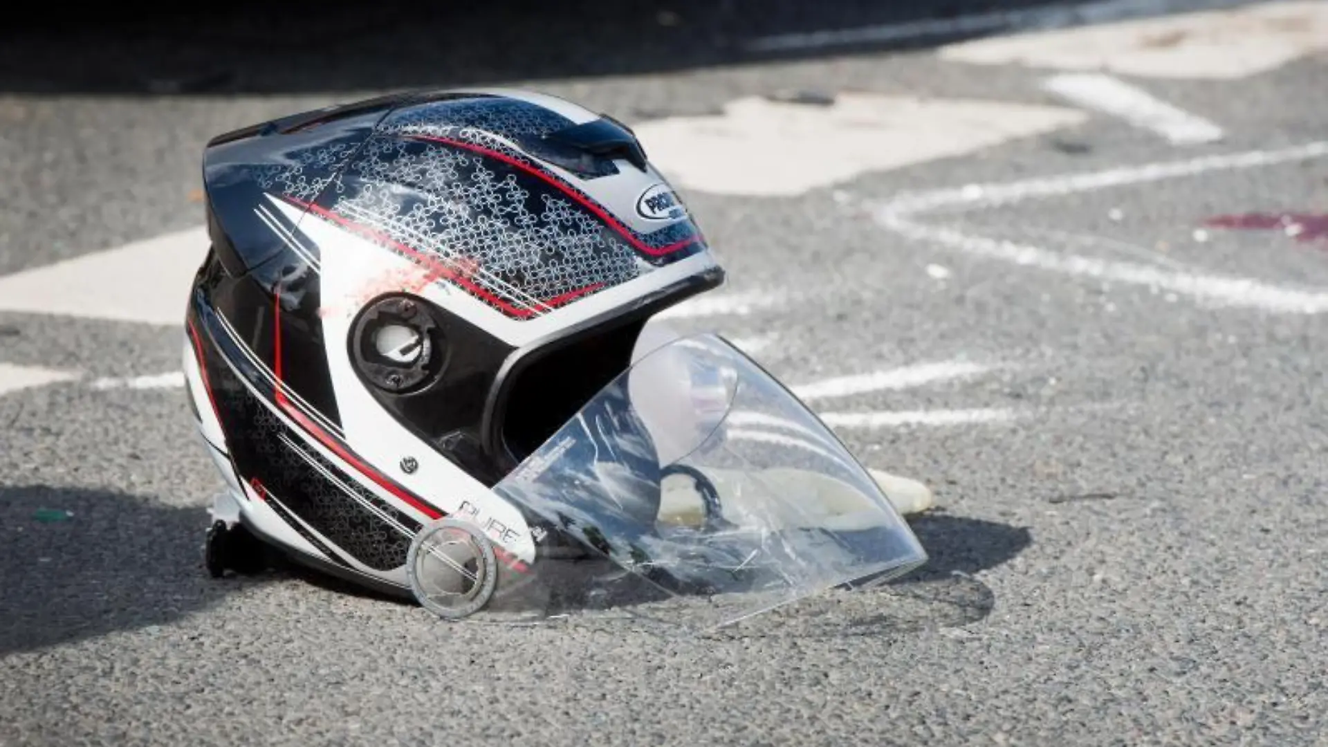 Ein beschädigter Motorradhelm liegt nach dem Unfall auf dem Boden