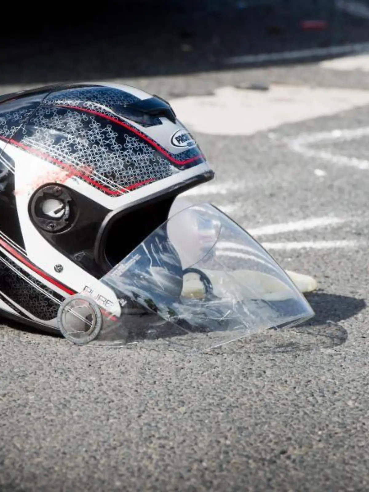 Ein beschädigter Motorradhelm liegt nach dem Unfall auf dem Boden