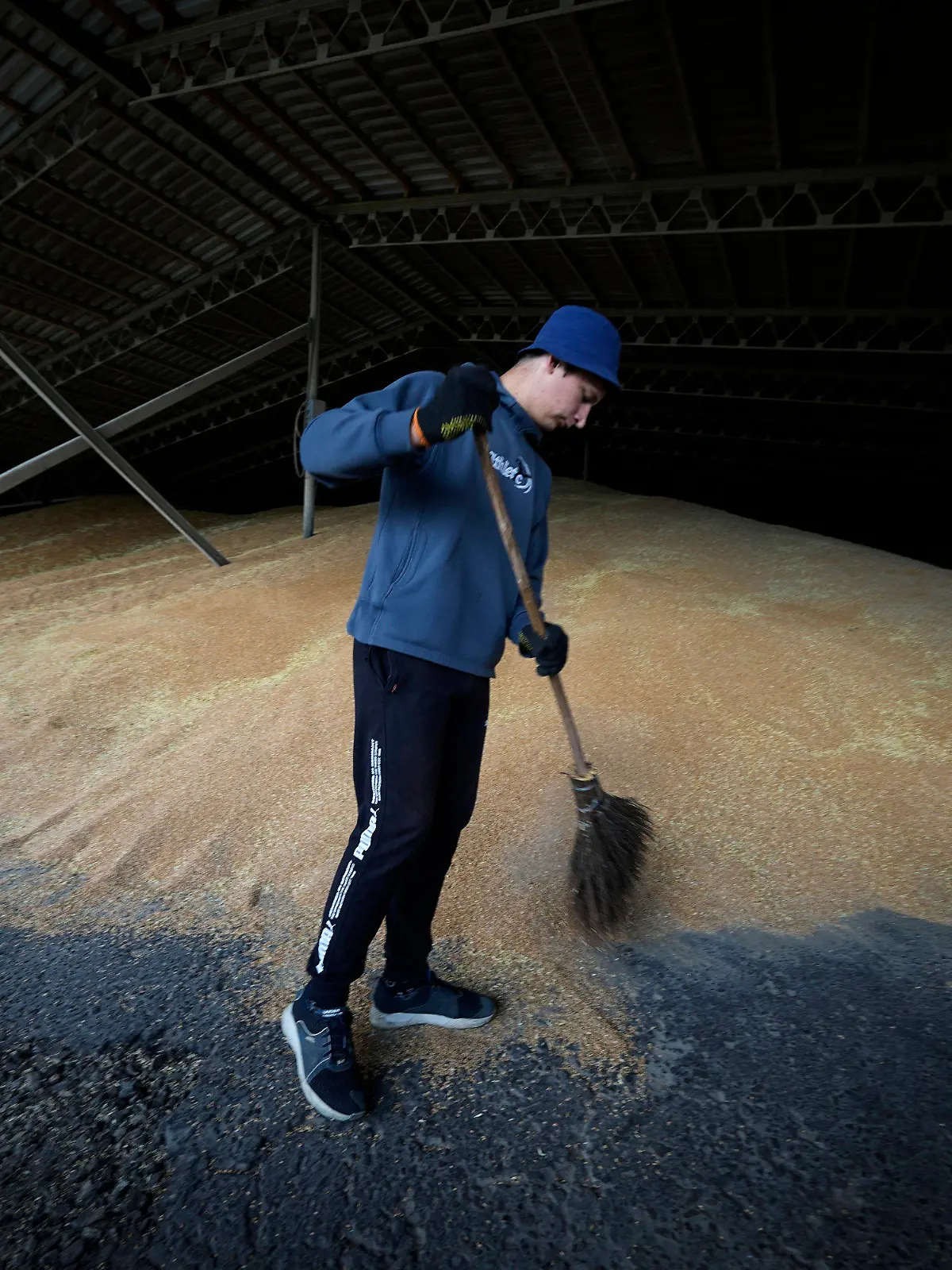 12.07.2022, Ukraine, Starobilsk: Ein Arbeiter trocknet das Getreide in einem landwirtschaftlichen Betrieb in Kalmychanks im Bezirk Starobilsk, auf dem Gebiet, das unter der Kontrolle der Regierung der Volksrepublik Luhansk steht, im Osten der Ukraine. Dieses Bild wurde während einer vom russischen Verteidigungsministerium organisierten Reise aufgenommen. Foto: Uncredited/AP/dpa +++ dpa-Bildfunk +++