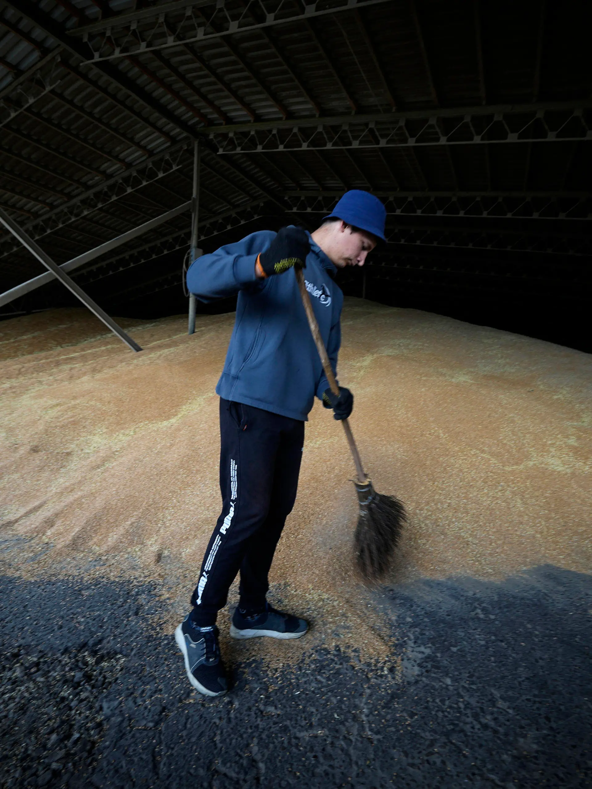 12.07.2022, Ukraine, Starobilsk: Ein Arbeiter trocknet das Getreide in einem landwirtschaftlichen Betrieb in Kalmychanks im Bezirk Starobilsk, auf dem Gebiet, das unter der Kontrolle der Regierung der Volksrepublik Luhansk steht, im Osten der Ukraine. Dieses Bild wurde während einer vom russischen Verteidigungsministerium organisierten Reise aufgenommen. Foto: Uncredited/AP/dpa +++ dpa-Bildfunk +++
