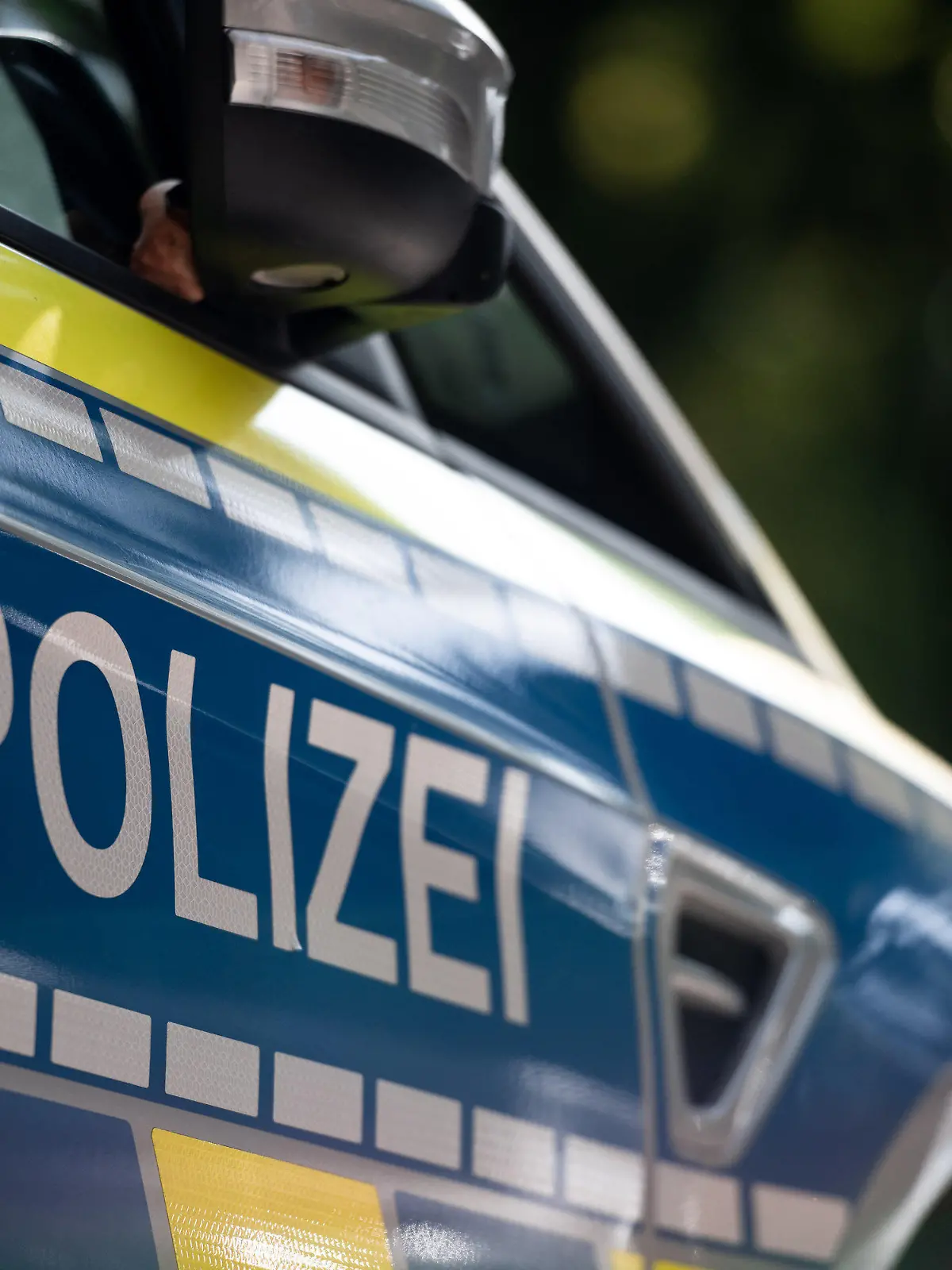 ARCHIV - 17.09.2020, Nordrhein-Westfalen, Oberhausen: Der Schriftzug «Polizei» steht auf einem Polizeiwagen. Ein 20 Jahre alter Sportwagenfahrer hat sich in Essen ein Rennen mit einer Streife geliefert. Der Essener hatte das Auto für seinen Geburtstag angemietet, wie die Polizei am Sonntagmorgen, 21. März 2021 mitteilte. (Zu dpa «20-Jähriger fordert Polizeiauto in Essen zum Rennen auf») Foto: Fabian Strauch/dpa +++ dpa-Bildfunk +++
