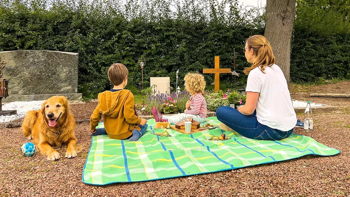 Daniela Süß mit ihren beiden Kindern und dem Familienhund am Grab ihres Mannes Bernd.