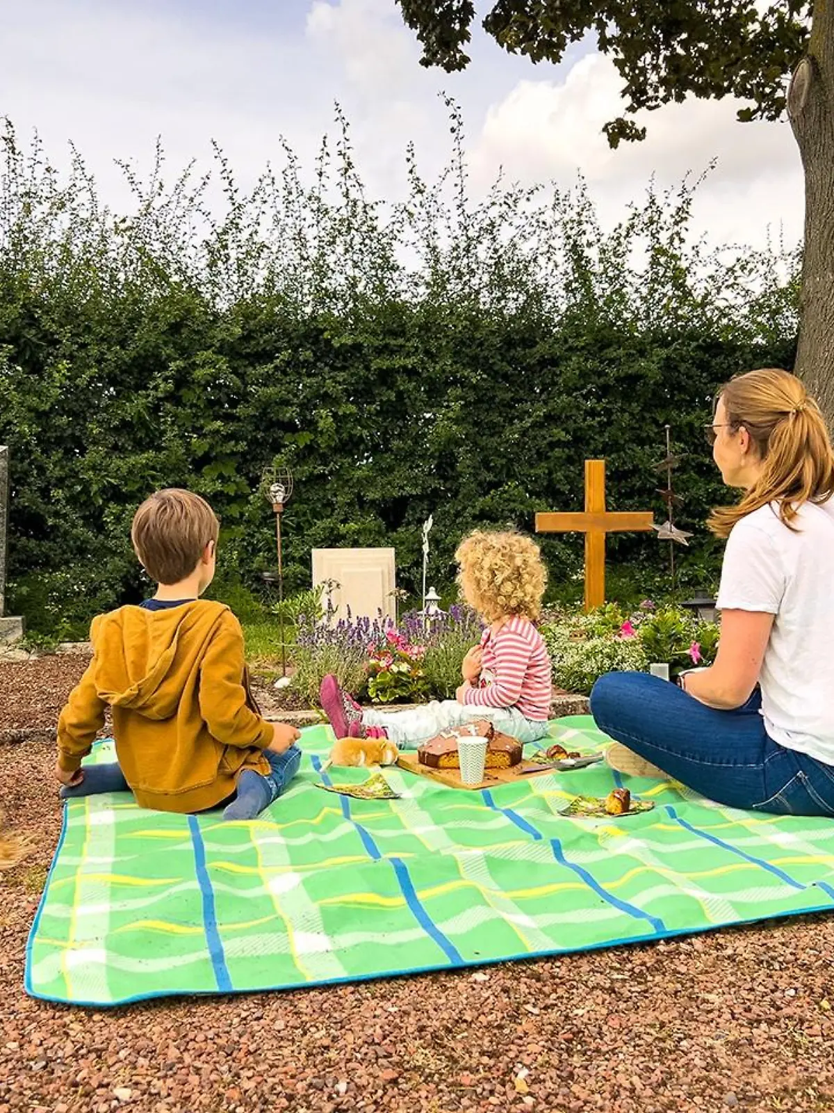 Daniela Süß mit ihren beiden Kindern und dem Familienhund am Grab ihres Mannes Bernd.