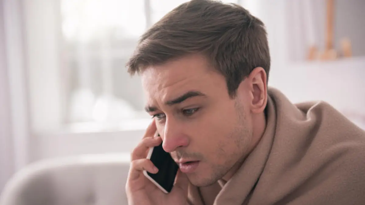 Phone conversation. Portrait of a nice handsome man pressing the phone to his ear while having a phone conversation
