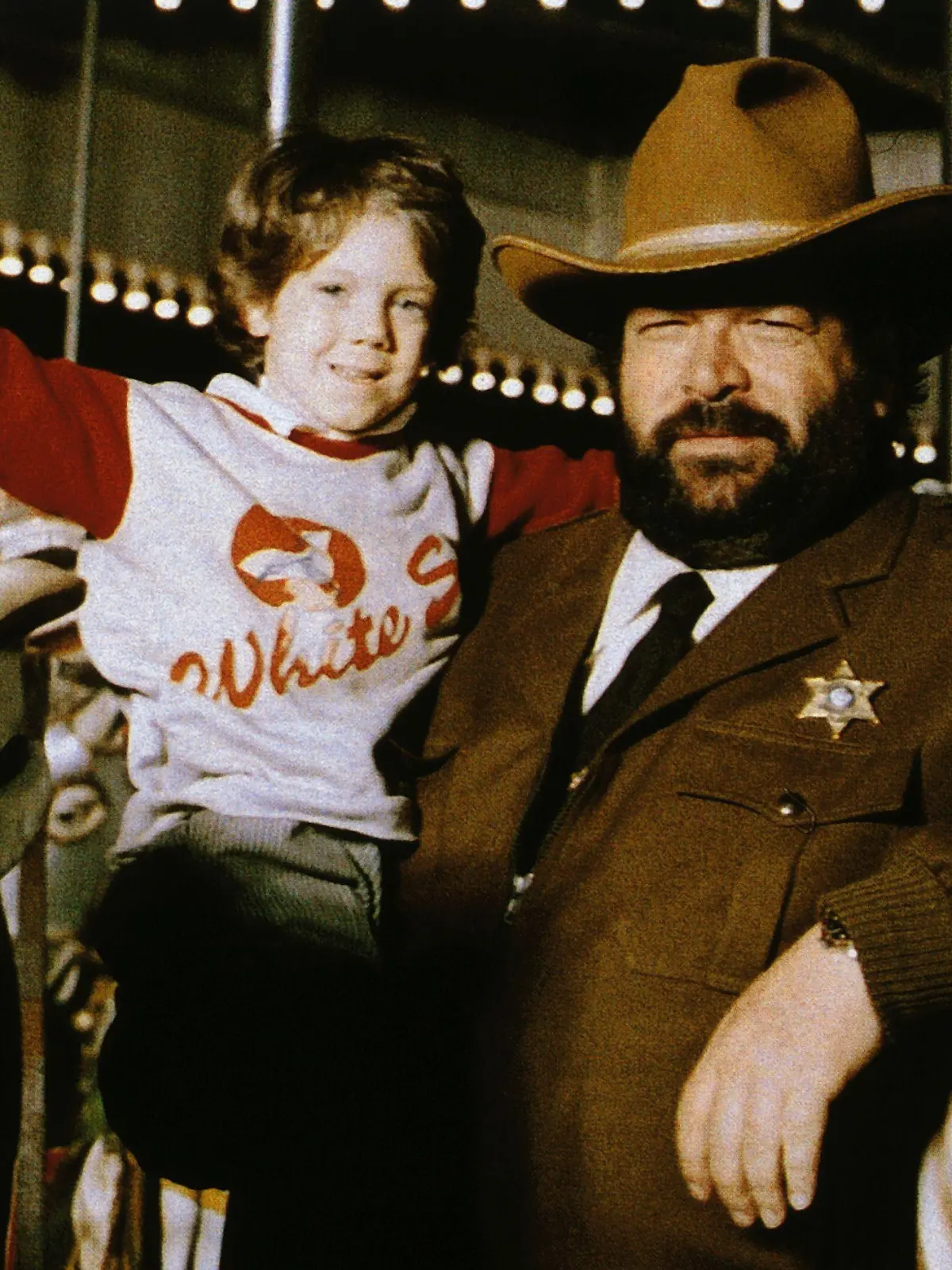 Sheriff Spencer (Bud Spencer, re.) hat auf einem Rummelplatz einen außergewöhnlichen Jungen aufgegabelt: "H-7-25" (Cary Guffey) kommt von einem fremden Planeten.