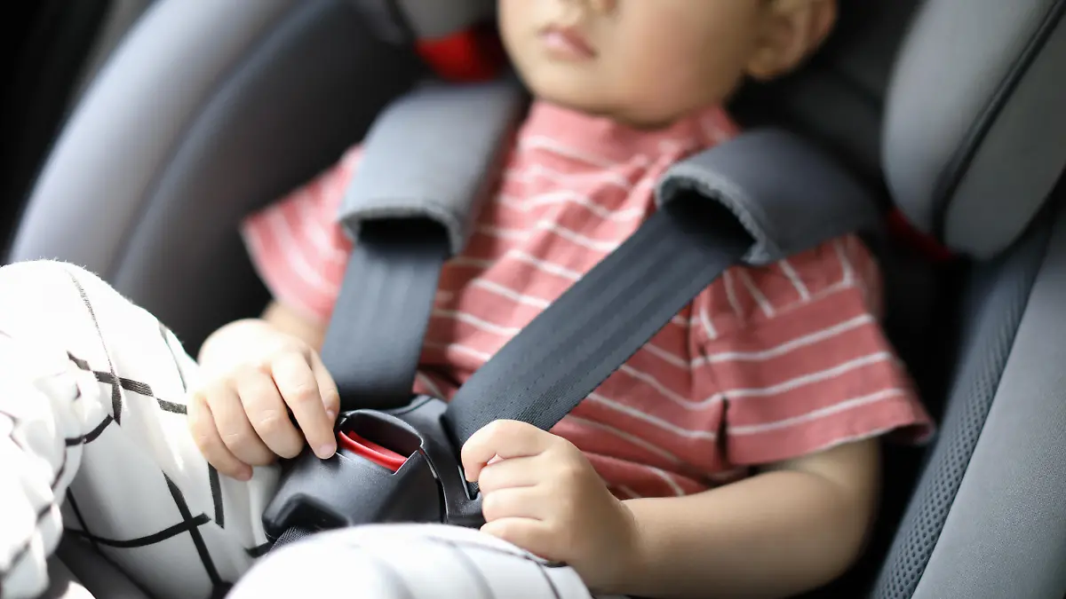 Infant baby boy buckled into her car seat
