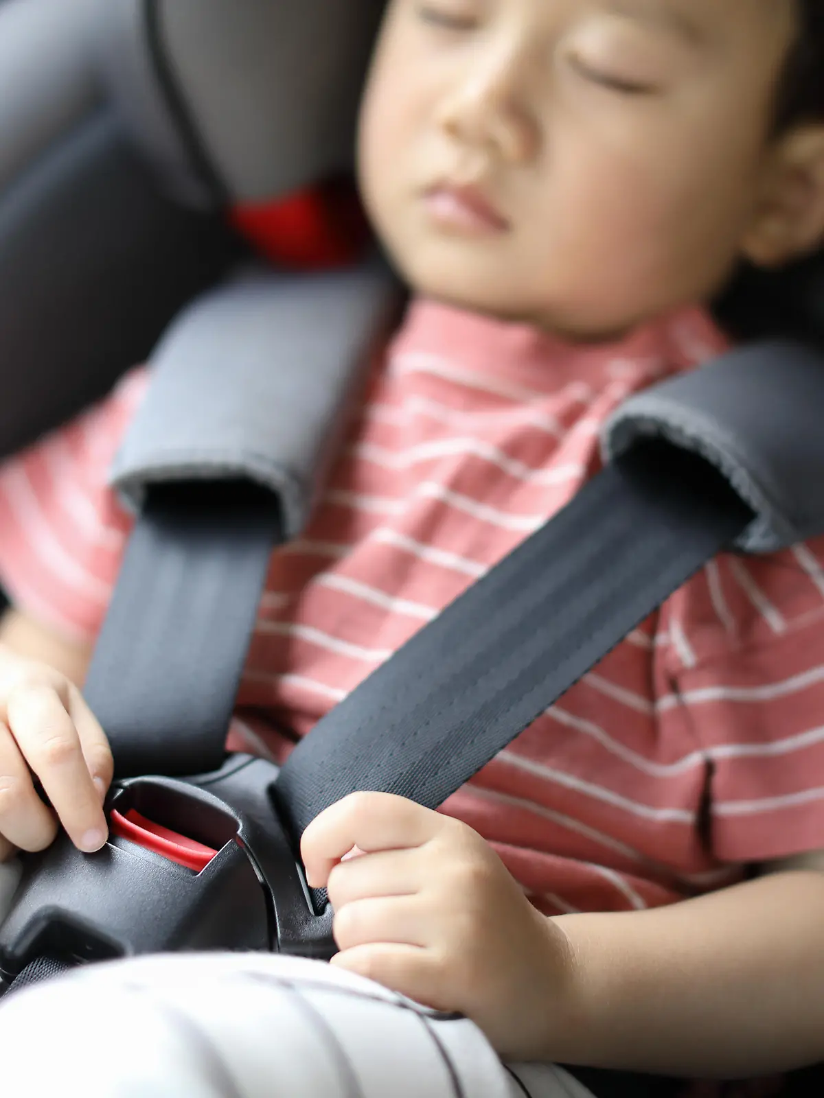Infant baby boy buckled into her car seat