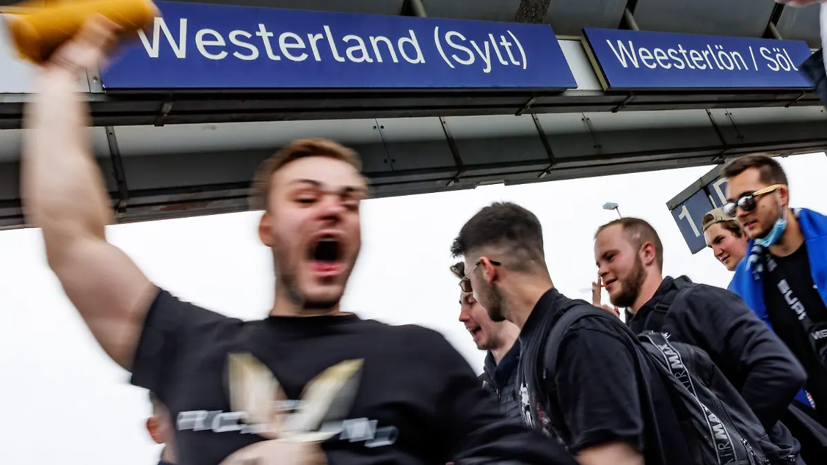 04.06.2022, Schleswig-Holstein, Westerland/Sylt: Ein Touristengruppe feiert auf dem Bahnhof von Westerland auf Sylt die Ankunft. Durch die Einführung des 9-Euro-Tickets haben sich die traditionell hohen Touristenzahlen an Pfingsten noch einmal erhöht. Foto: Axel Heimken/dpa - ACHTUNG: Nur zur redaktionellen Verwendung im Zusammenhang mit der aktuellen Berichterstattung und nur mit vollständiger Nennung des vorstehenden Credits +++ dpa-Bildfunk +++
