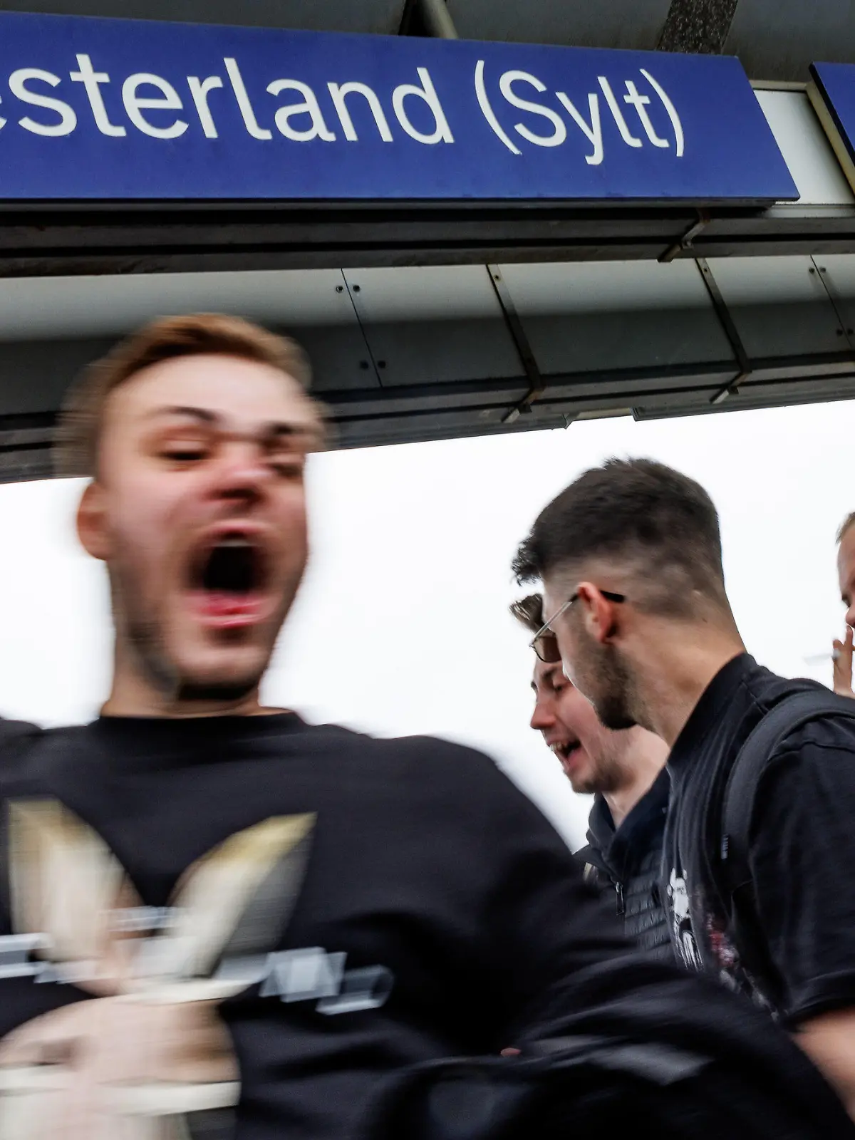 04.06.2022, Schleswig-Holstein, Westerland/Sylt: Ein Touristengruppe feiert auf dem Bahnhof von Westerland auf Sylt die Ankunft. Durch die Einführung des 9-Euro-Tickets haben sich die traditionell hohen Touristenzahlen an Pfingsten noch einmal erhöht. Foto: Axel Heimken/dpa - ACHTUNG: Nur zur redaktionellen Verwendung im Zusammenhang mit der aktuellen Berichterstattung und nur mit vollständiger Nennung des vorstehenden Credits +++ dpa-Bildfunk +++