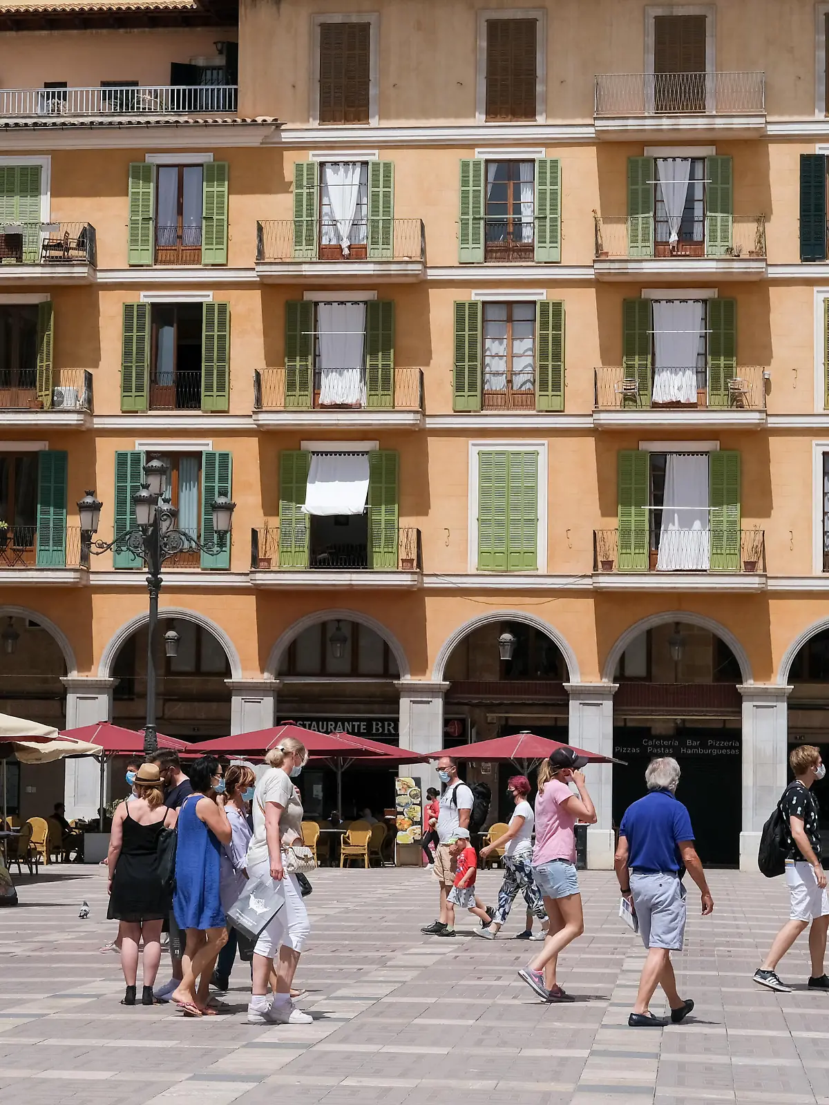 Touristen gehen über den Plaza Major.