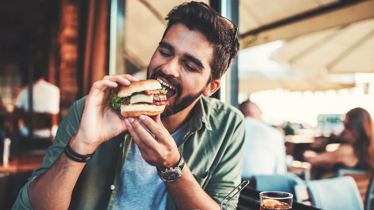 Young man sitting in a cafe and enjoying in breakfast. Food, lifestyle concept