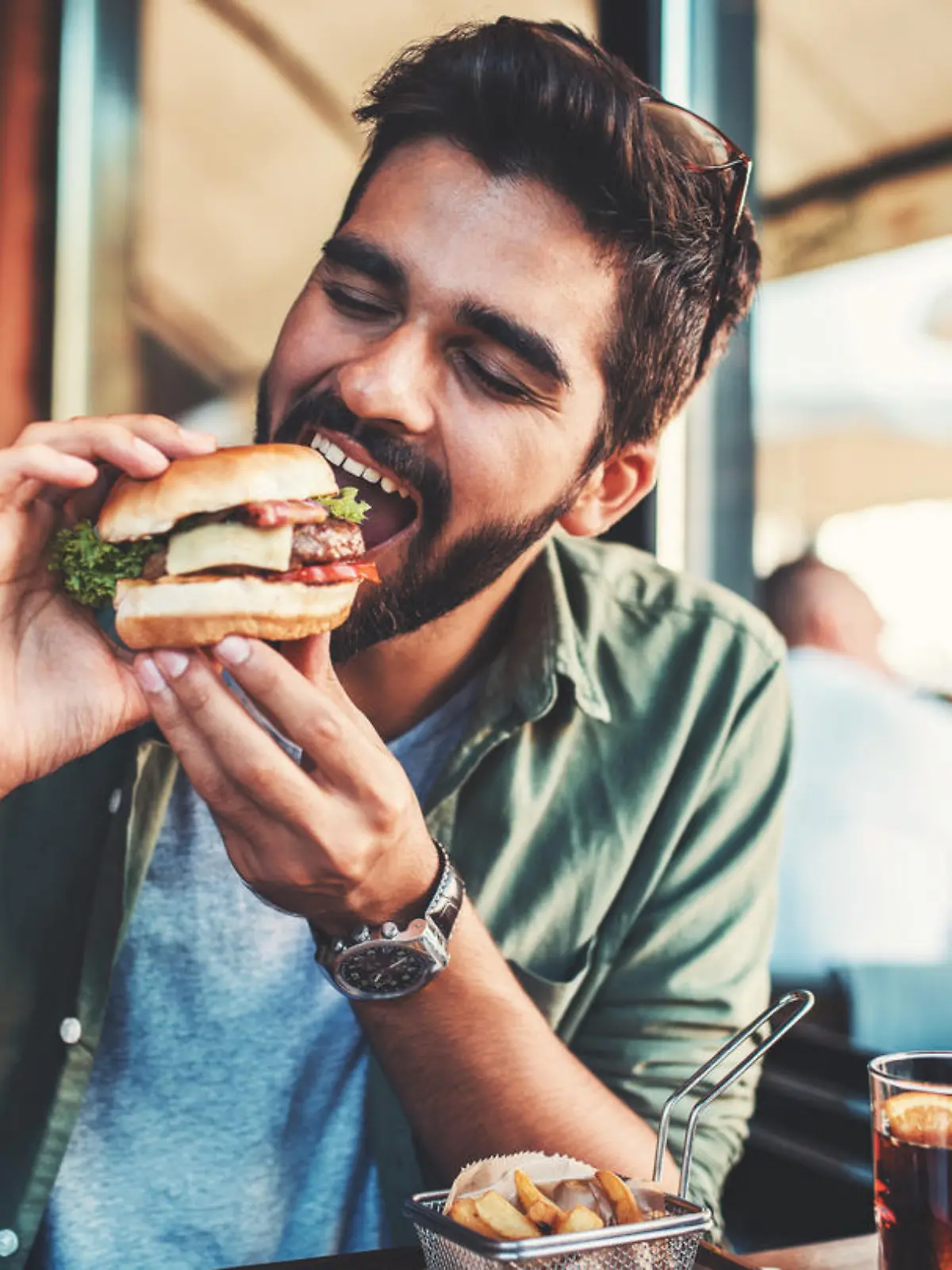 Young man sitting in a cafe and enjoying in breakfast. Food, lifestyle concept