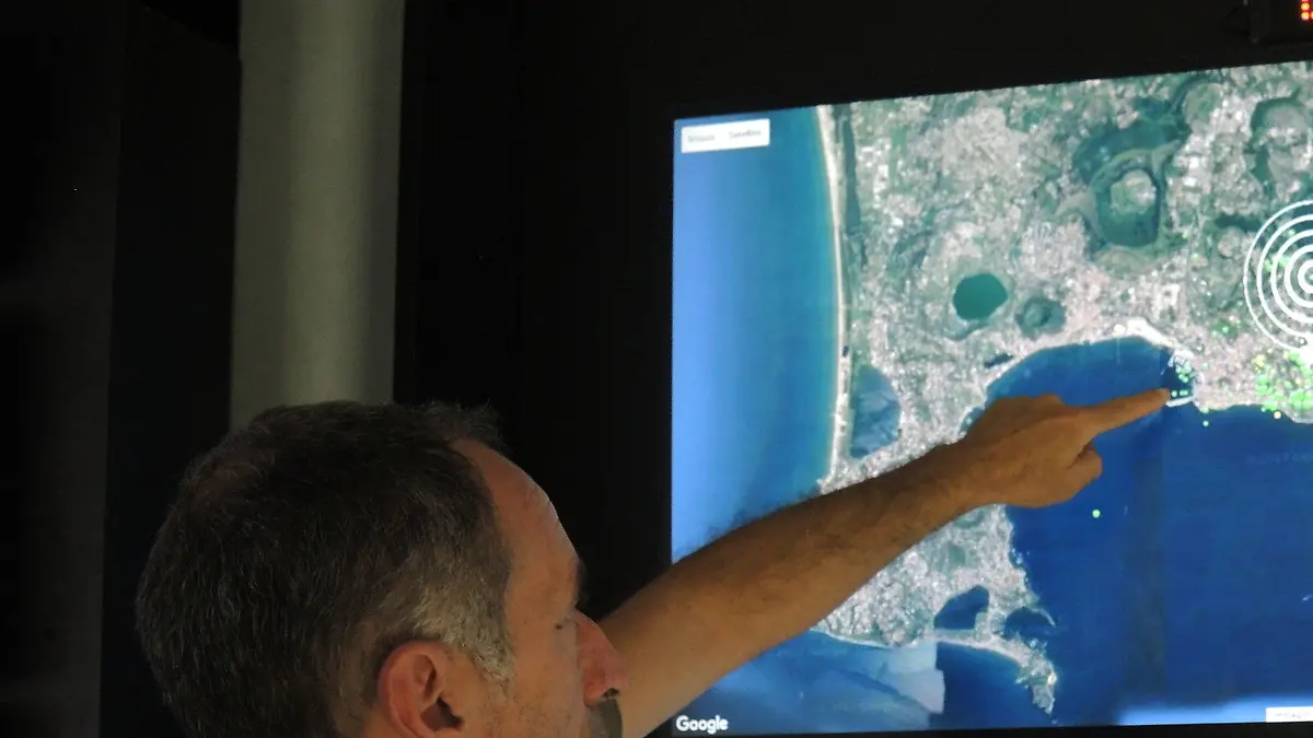 Der Geologe Roberto Isaia zeigt im Vulkan-Observatorium des Nationalen Instituts für Geophysik und Vulkanologie (INGV) in Neapel (Italien) am 16.06.2017 auf eine Satellitenaufnahme des Golfs von Neapel. Rund um die Uhr werden hier die Vulkane Vesuv, Phlegräische Felder und Ischia überwacht. (zu dpa «Der Vulkanriese in der Tiefe - «Wir stecken im Schlamassel»» vom 05.07.2017) Foto: Lena Klimkeit/dpa +++(c) dpa - Bildfunk+++