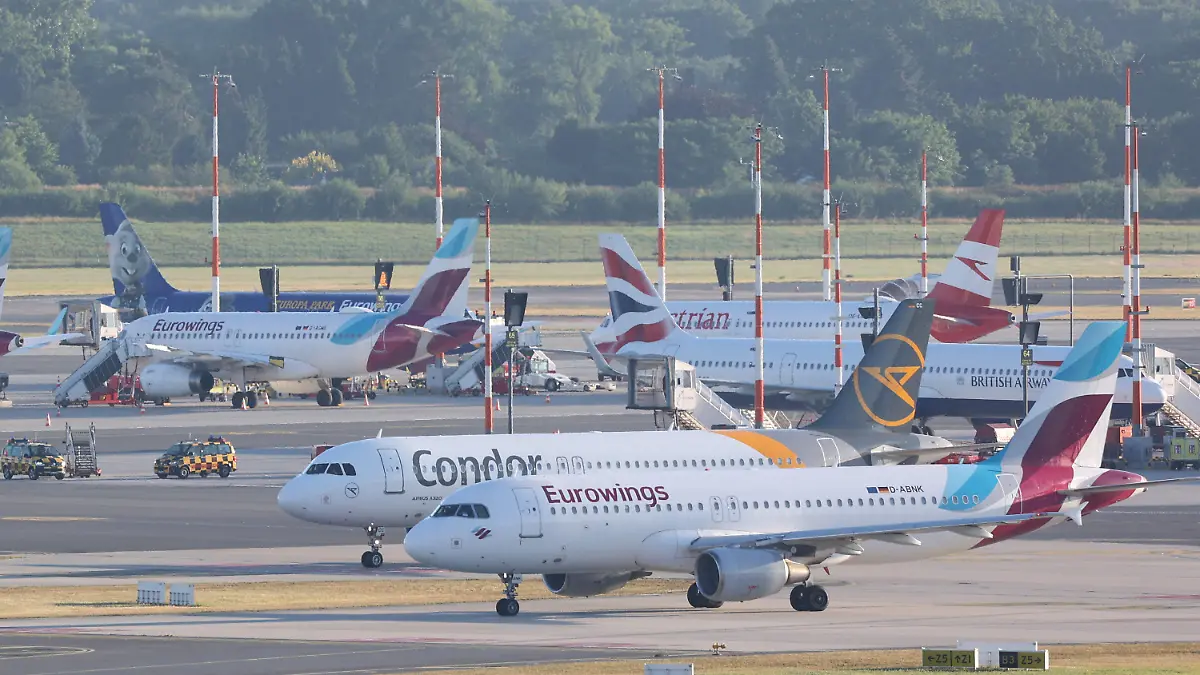 02.07.2022, Hamburg: Flugzeuge stehen am Hamburger Flughafen. Jeweils eine Maschine der Fluggesellschaften Eurowings und Condor rollen zu Startbahn. In Schleswig-Holstein haben die Ferien begonnen. Foto: Bodo Marks/dpa +++ dpa-Bildfunk +++