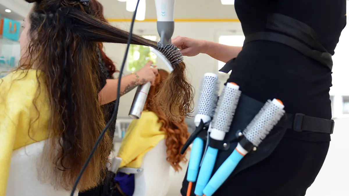 ARCHIV - ILLUSTRATION - Eine Friseurin föhnt einer Kundin am 07.08.2012 in Berlin die Haare. Raus aus dem beruflichen Alltagstrott und rein ins kalte Wasser - nur wenige Menschen in Deutschland trauen sich mit über 40, noch einmal ganz von vorne anzufangen und eine Ausbildung zu machen. Dabei kann das durchaus neuen Schwung geben. Foto: Britta Pedersen/dpa (zu dpa-KORR: «Neustart in der Lebensmitte - Azubi mit 40 plus» vom 22.10.2013) +++(c) dpa - Bildfunk+++