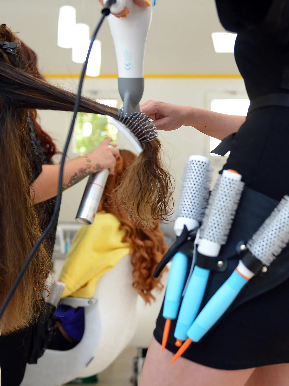 ARCHIV - ILLUSTRATION - Eine Friseurin föhnt einer Kundin am 07.08.2012 in Berlin die Haare. Raus aus dem beruflichen Alltagstrott und rein ins kalte Wasser - nur wenige Menschen in Deutschland trauen sich mit über 40, noch einmal ganz von vorne anzufangen und eine Ausbildung zu machen. Dabei kann das durchaus neuen Schwung geben. Foto: Britta Pedersen/dpa (zu dpa-KORR: «Neustart in der Lebensmitte - Azubi mit 40 plus» vom 22.10.2013) +++(c) dpa - Bildfunk+++