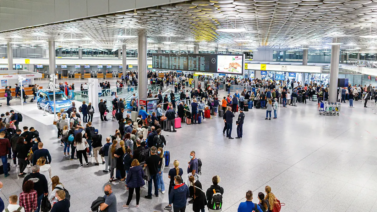 02.10.2021, Niedersachsen, Langenhagen: Reisende warten im Terminal C vom Flughafen Hannover-Langenhagen auf die Sicherheitsabfertigung. Weil der von der Bundespolizei für die Abfertigungs-Kontrollen beauftragte Dienstleister massive Personalprobleme hat, kam es zuletzt zu großen Wartezeiten, teilweise verpassten Reisende deswegen ihre Flüge. Foto: Michael Matthey/dpa +++ dpa-Bildfunk +++
