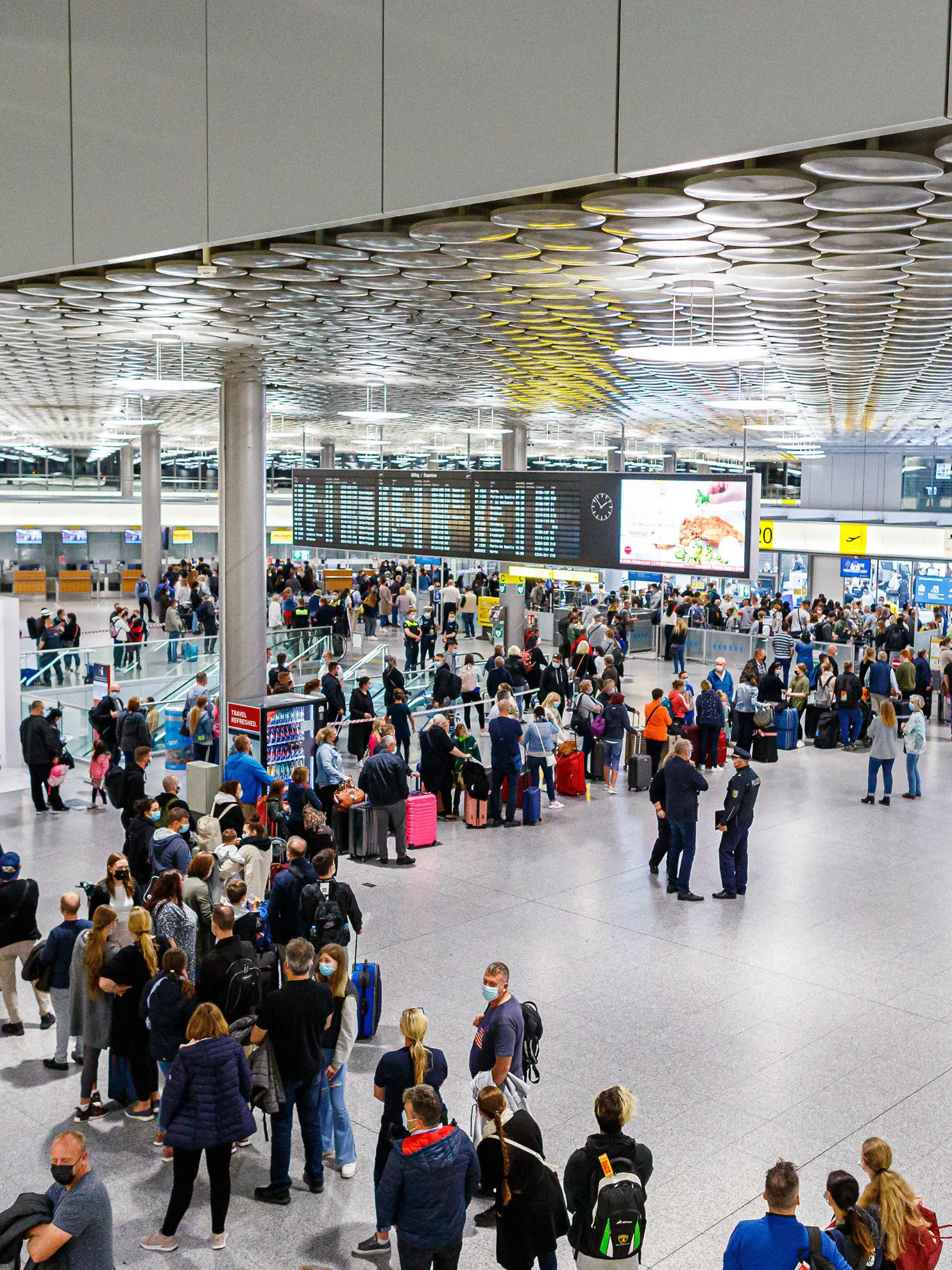 02.10.2021, Niedersachsen, Langenhagen: Reisende warten im Terminal C vom Flughafen Hannover-Langenhagen auf die Sicherheitsabfertigung. Weil der von der Bundespolizei für die Abfertigungs-Kontrollen beauftragte Dienstleister massive Personalprobleme hat, kam es zuletzt zu großen Wartezeiten, teilweise verpassten Reisende deswegen ihre Flüge. Foto: Michael Matthey/dpa +++ dpa-Bildfunk +++