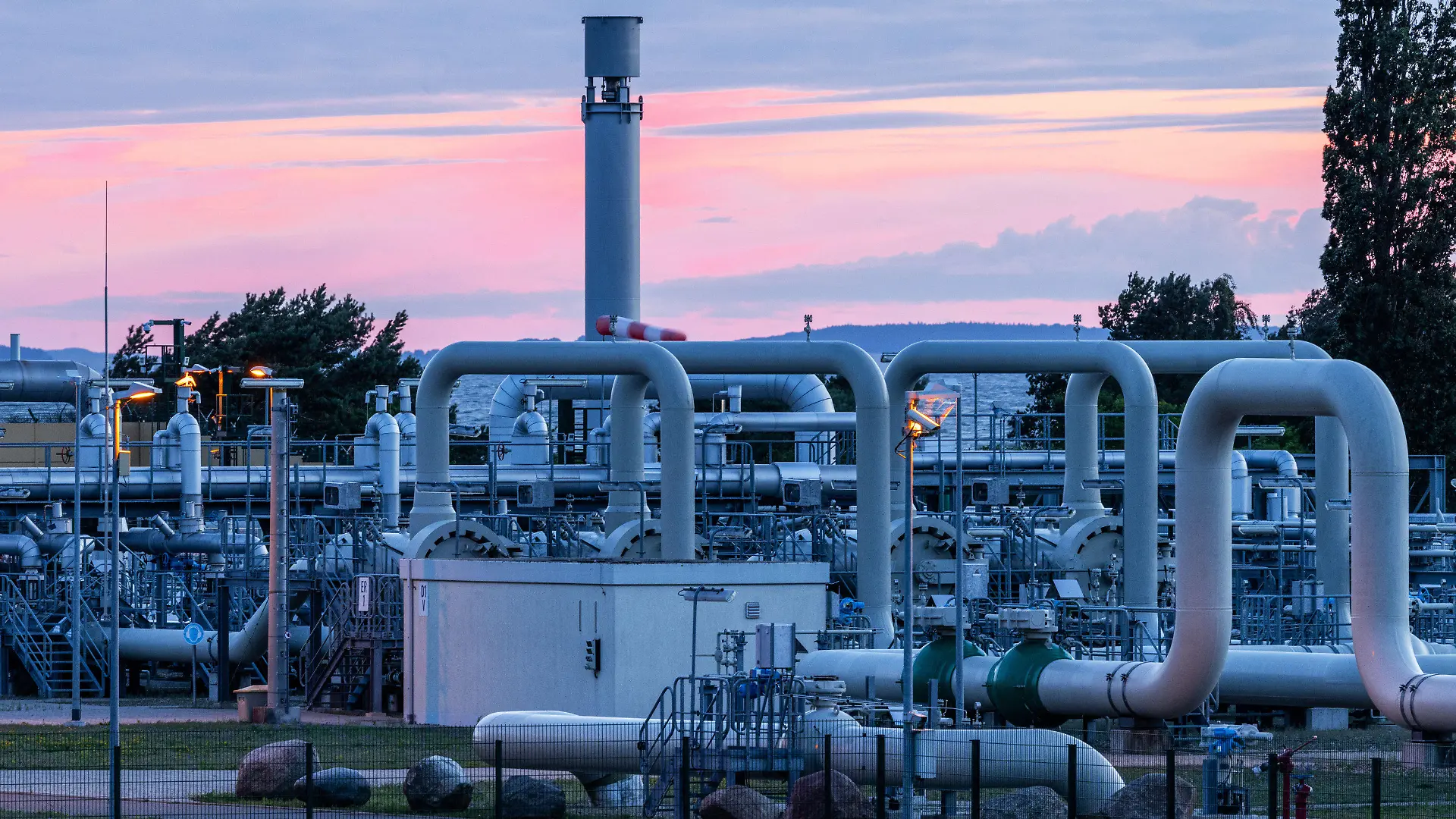 11.07.2022, Mecklenburg-Vorpommern, Lubmin: Rohrsysteme und Absperrvorrichtungen in der Gasempfangsstation der Ostseepipeline Nord Stream 1 und der Übernahmestation der Ferngasleitung OPAL (Ostsee-Pipeline-Anbindungsleitung) sind vor Sonnenaufgang zu sehen. Die Ostsee-Pipeline Nord Stream 1, durch die seit 2011 russisches Erdgas nach Deutschland fließt, wird wegen planungsmäßiger Wartungsarbeiten für etwa zehn Tage abgeschaltet. Foto: Jens Büttner/dpa +++ dpa-Bildfunk +++