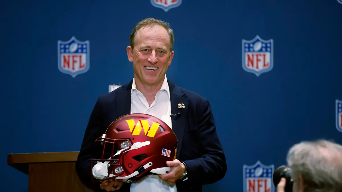 Josh Harris, leader of a group buying the Washington Commanders, poses with a team helmet after NFL owners voted to approve the sale in Bloomington, Minn., Thursday, July 20, 2023. (AP Photo/Bruce Kluckhohn)