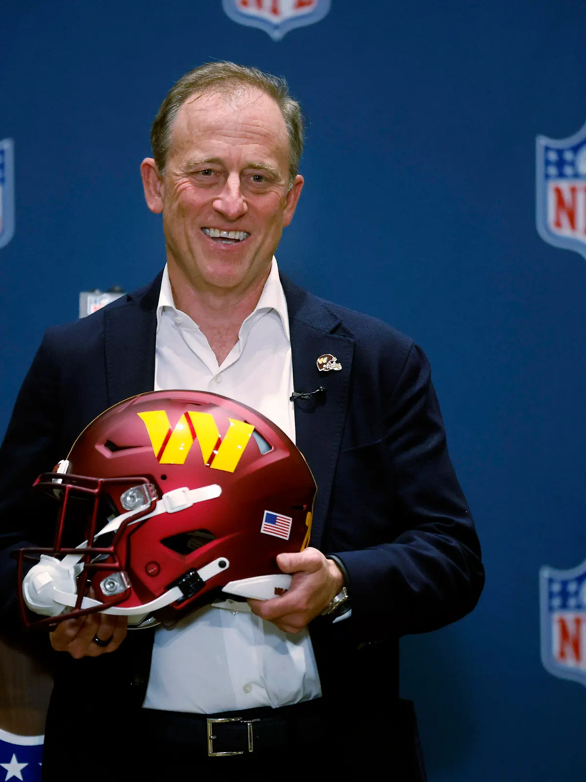 Josh Harris, leader of a group buying the Washington Commanders, poses with a team helmet after NFL owners voted to approve the sale in Bloomington, Minn., Thursday, July 20, 2023. (AP Photo/Bruce Kluckhohn)