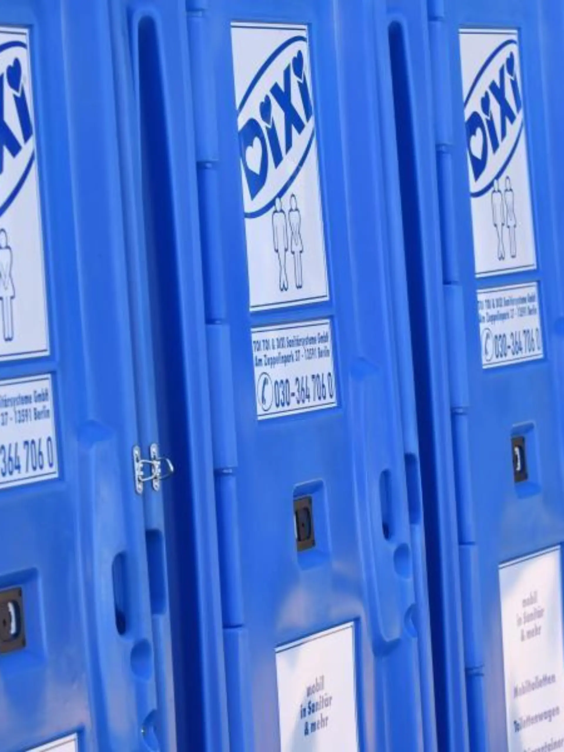Toilettenhäuschen der Firma Dixi stehen aufgereiht nebeneinander