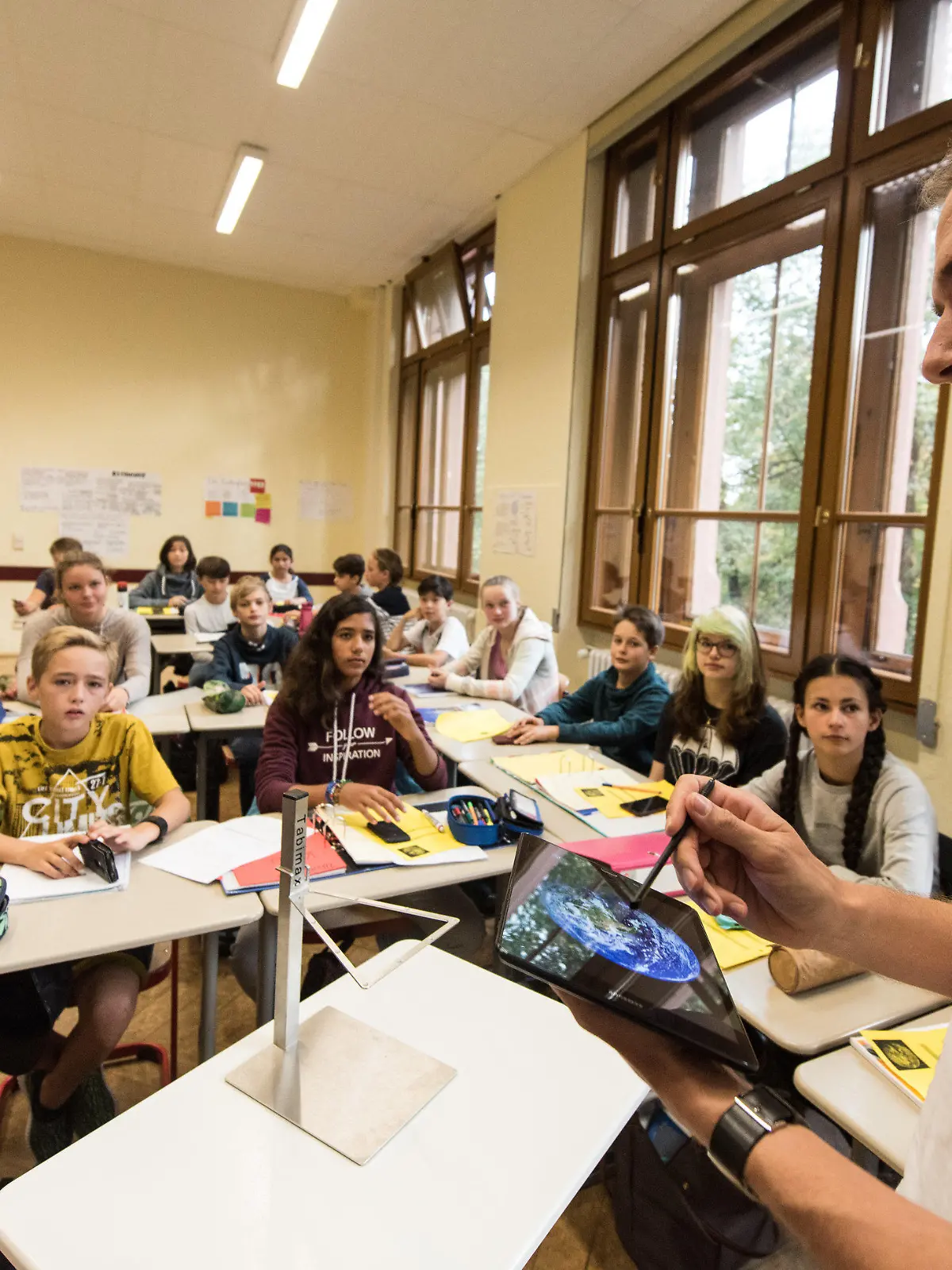 Physiklehrer Patrick Bronner steht am 23.09.2016 im Friedrich-Gymnasium in Freiburg (Baden-Württemberg) und unterrichtet seine Klasse mit einem Tabletcomputer. Schüler erarbeiten Ergebnisse mit dem Smartphone. Wissenschaftler schauen, ob das Projekt funktioniert. Es hat bundesweiten Pilotcharakter. Das Projekt hat am 26.09.2016 in Berlin einen «Deutschen Lehrerpreis 2016» für innovativen Unterricht erhalten. Foto: Patrick Seeger/dpa (zu lsw-KORR: «Smartphone und Tablet gestalten in Freiburg den Unterricht» vom 26.09.2016) +++(c) dpa - Bildfunk+++