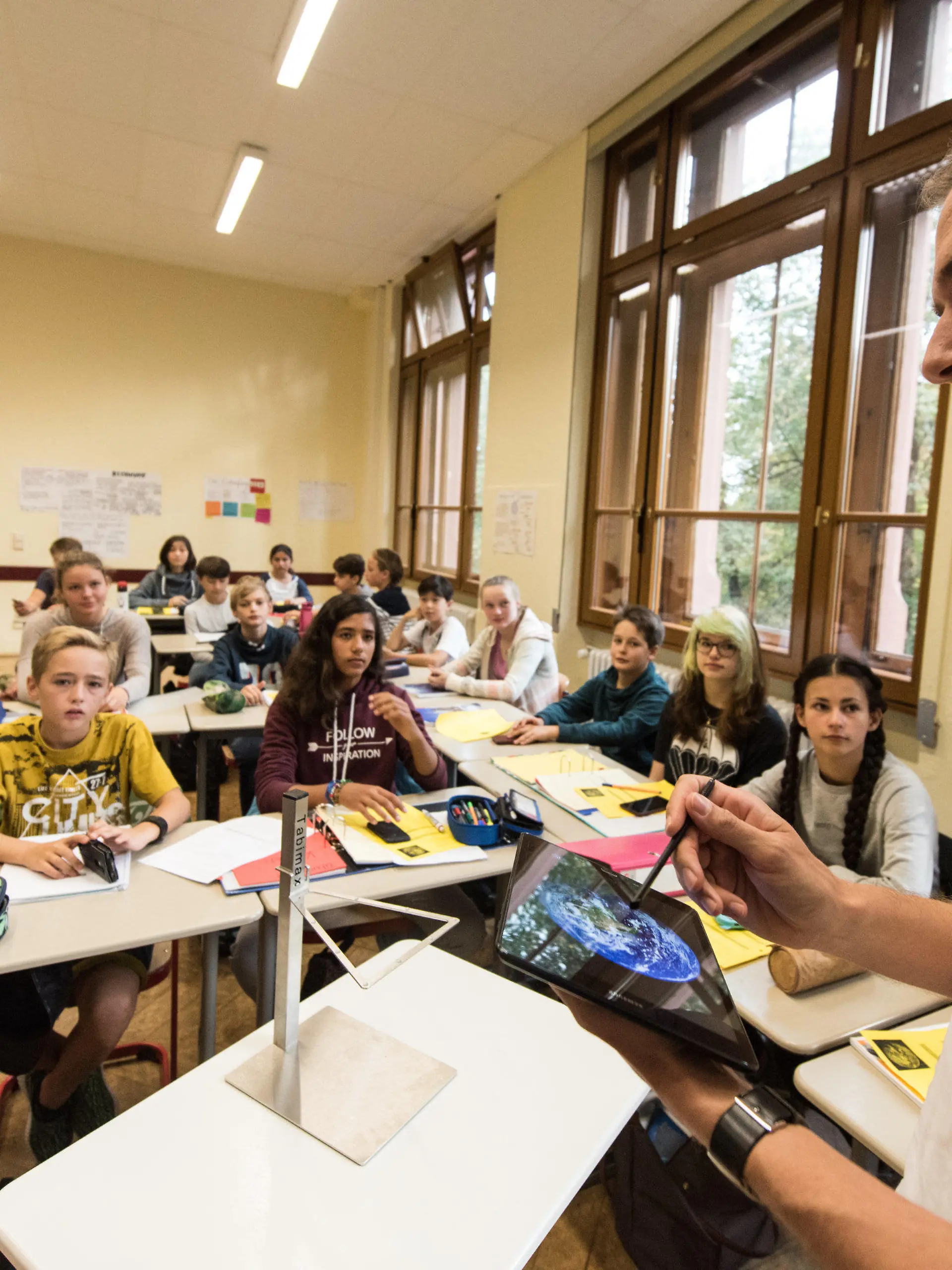 Physiklehrer Patrick Bronner steht am 23.09.2016 im Friedrich-Gymnasium in Freiburg (Baden-Württemberg) und unterrichtet seine Klasse mit einem Tabletcomputer. Schüler erarbeiten Ergebnisse mit dem Smartphone. Wissenschaftler schauen, ob das Projekt funktioniert. Es hat bundesweiten Pilotcharakter. Das Projekt hat am 26.09.2016 in Berlin einen «Deutschen Lehrerpreis 2016» für innovativen Unterricht erhalten. Foto: Patrick Seeger/dpa (zu lsw-KORR: «Smartphone und Tablet gestalten in Freiburg den Unterricht» vom 26.09.2016) +++(c) dpa - Bildfunk+++